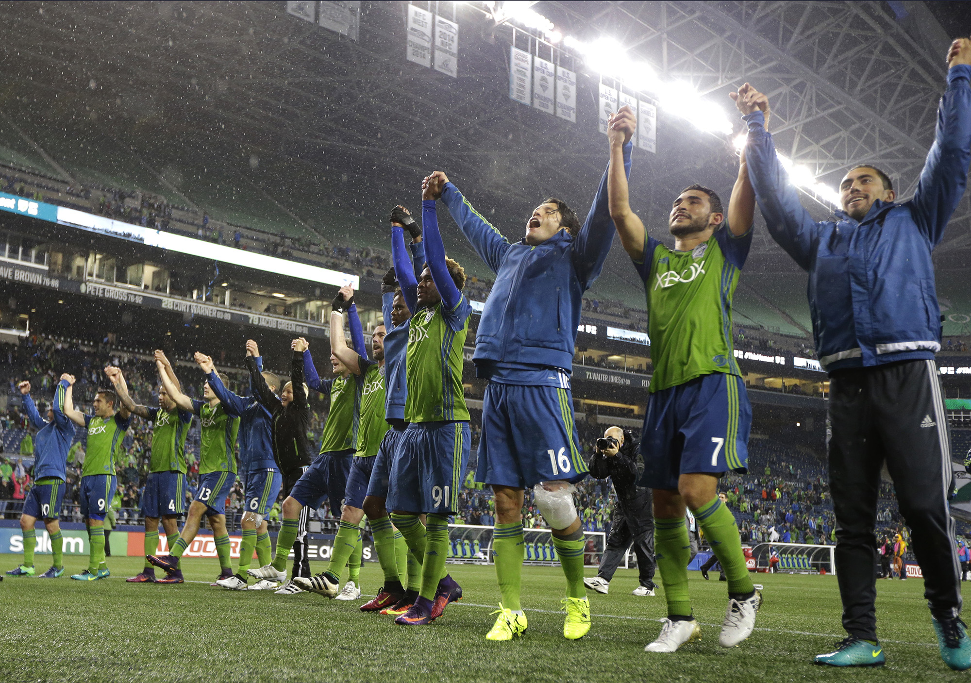 Seattle Sounders players, including Cristian Roldan (7) and Nelson Haedo Valdez (16) celebrate after they beat FC Dallas 3-0 in an MLS soccer playoff match, Sunday, Oct. 30, 2016, in Seattle. (Ted S. Warren/AP)