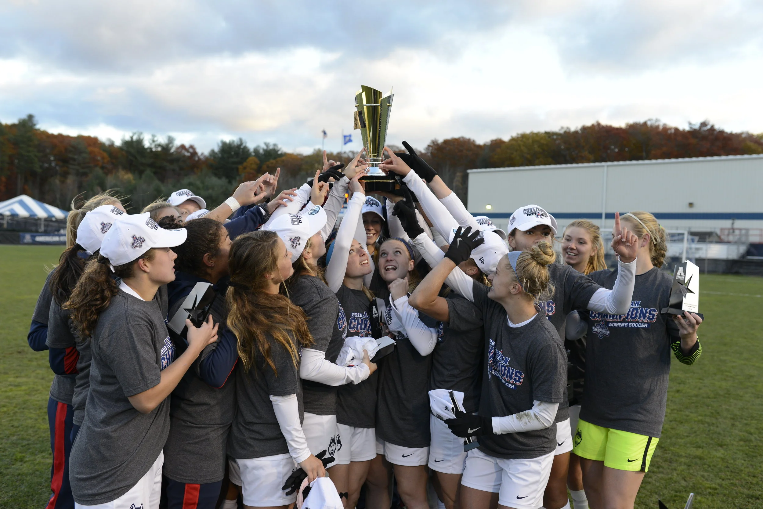 The UConn women's soccer team admires their trophy following a 1-0 victory over SMU on Sunday, Nov. 6 at Joseph J. Morrone Stadium. The Huskies took home their second American Athletic Conference title in program history. (Jason Jiang/The Daily Campus)