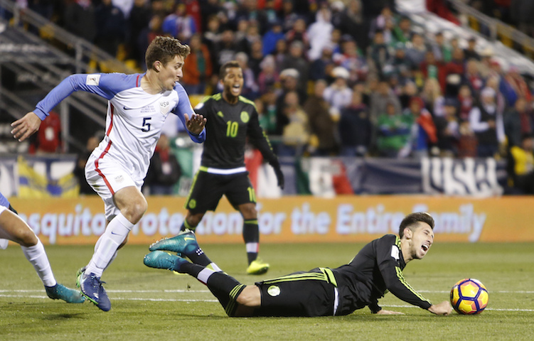 Mexico's Hector Herrera, right, falls to the ground as United States' Matt Besler looks for the ball during the second half of a World Cup qualifying soccer match Friday, Nov. 11, 2016, in Columbus, Ohio. (Jay LaPrete/AP Photo)