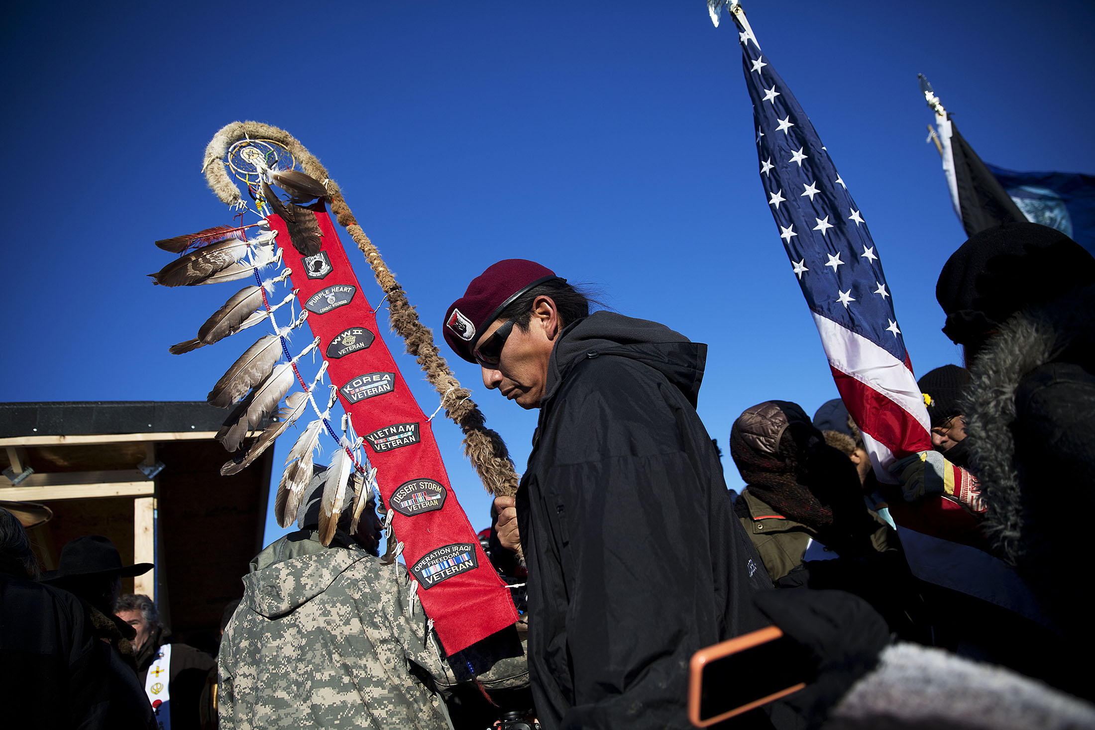Native American veterans join an interfaith ceremony at the Oceti Sakowin camp where people have gathered to protest the Dakota Access oil pipeline in Cannon Ball, N.D., Sunday, Dec. 4, 2016. Tribal elders have asked the military veterans joining the large Dakota Access pipeline protest encampment not to have confrontations with law enforcement officials, an organizer with Veterans Stand for Standing Rock said Sunday, adding the group is there to help out those who've dug in against the four-state, $3.8 billion project. (AP Photo/David Goldman)