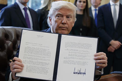President Donald Trump shows off his signature on an executive order about the Dakota Access pipeline, Tuesday, Jan. 24, 2017, in the Oval Office of the White House in Washington. (Evan Vucci/AP)