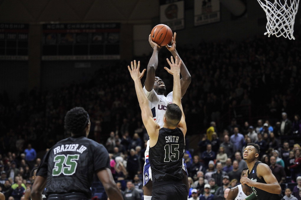 Amida Brimah gets up for a layup over Tulane's Ryan Smith in Saturday's win over the Green Wave at Gampel Pavilion. (Jason Jiang/The Daily Campus)