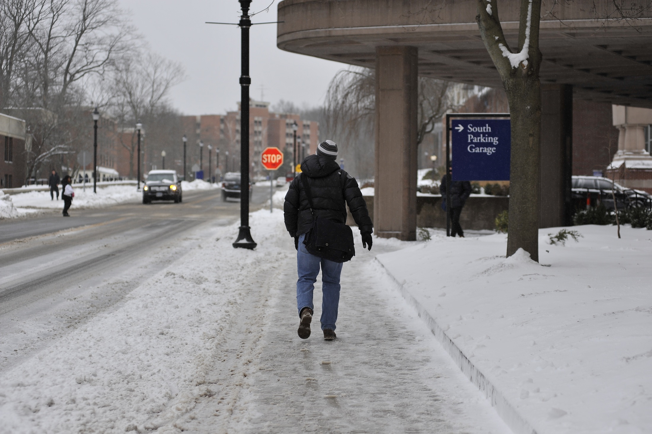 A student walks across campus on February 8th, 2017 during a snowstorm. (Jason Jiang/The Daily Campus)