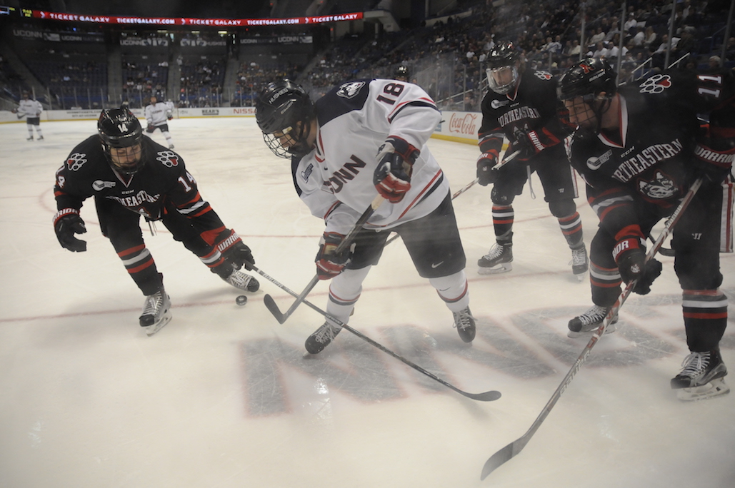 UConn's Max Kalter (#18) battles for the puck while surrounded by Northeastern players during UConn's loss Friday night. (Angie DeRosa/The Daily Campus)