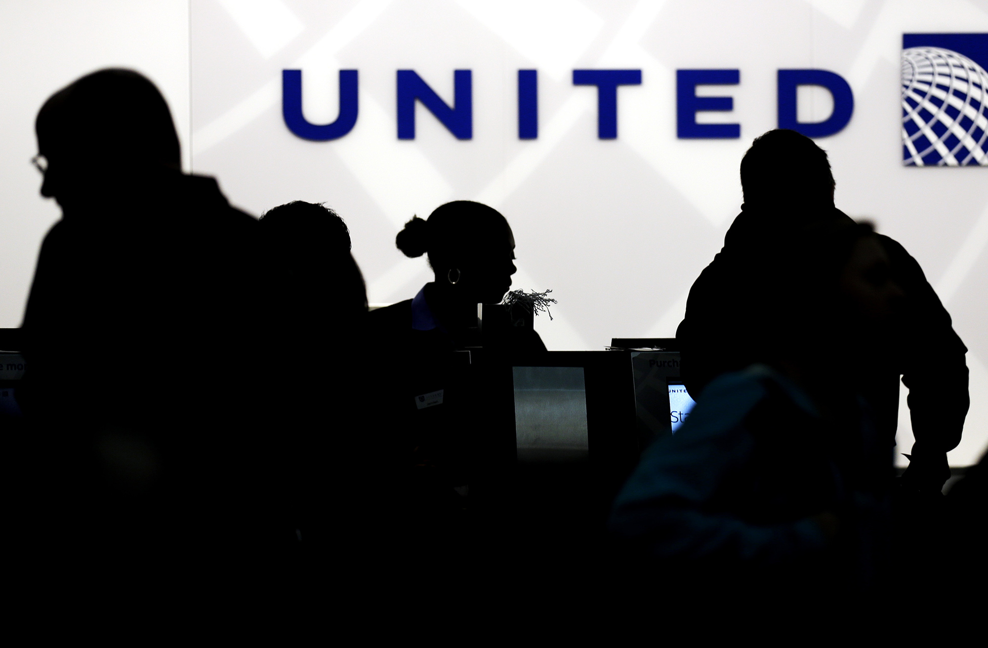  In this Saturday, Dec. 21, 2013, file photo, travelers check in at the United Airlines. After a man is dragged off a United Express flight on Sunday, April 9, 2017, United Airlines becomes the butt of jokes online and on late-night TV. Travel and public-relations experts say United has fumbled the situation from the start. (Nam Y. Huh/AP)