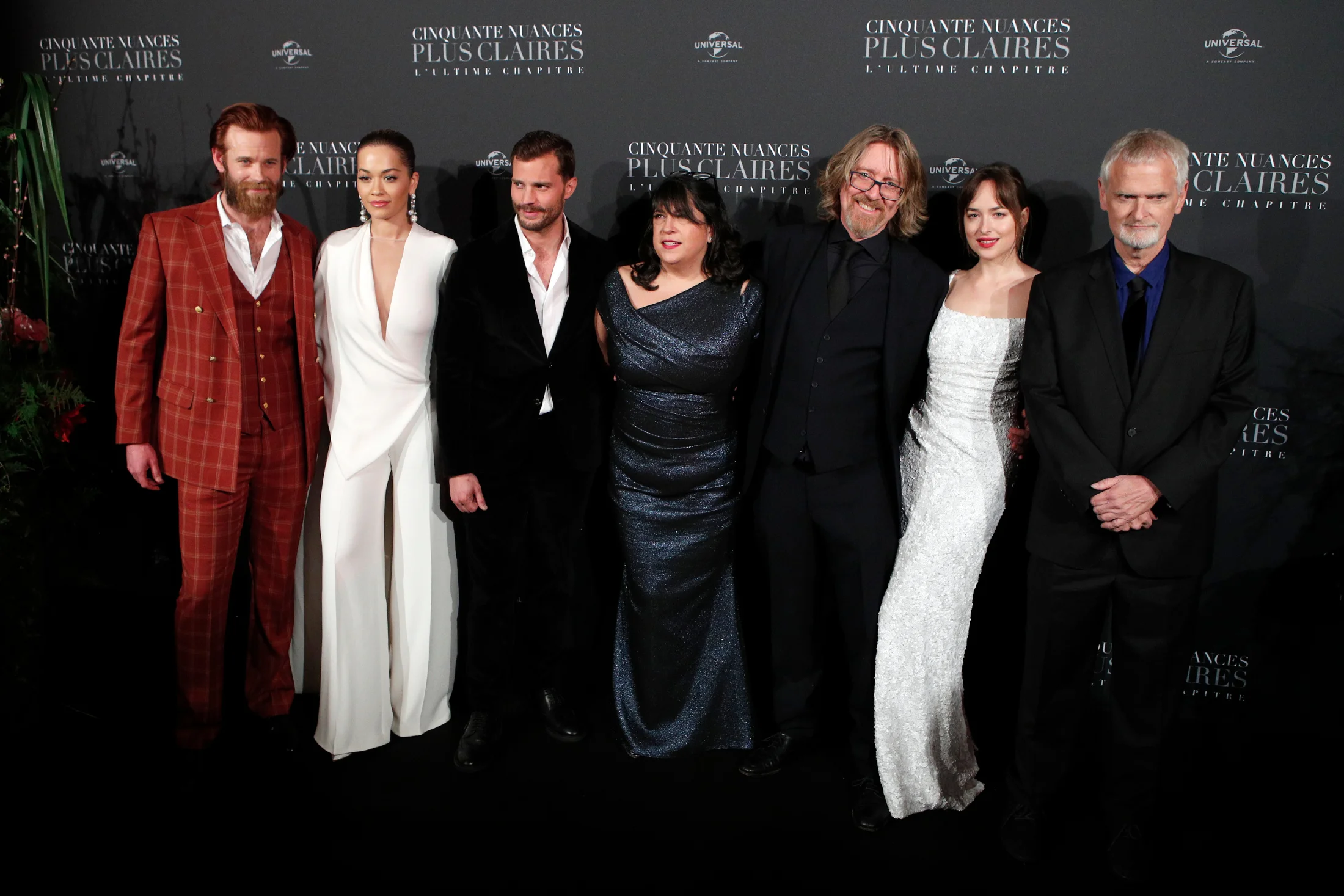 From left to right, Eric Johnson, Rita Ora, Jamie Dornan, E.L. James, a guest, Dakota Johnson, and James Foley pose during a photocall for the world premiere of 'Fifty Shades Freed - 50 Nuances Plus Claires' at Salle Pleyel in Paris, Tuesday, Feb. 6, 2018. (AP Photo/Francois Mori)