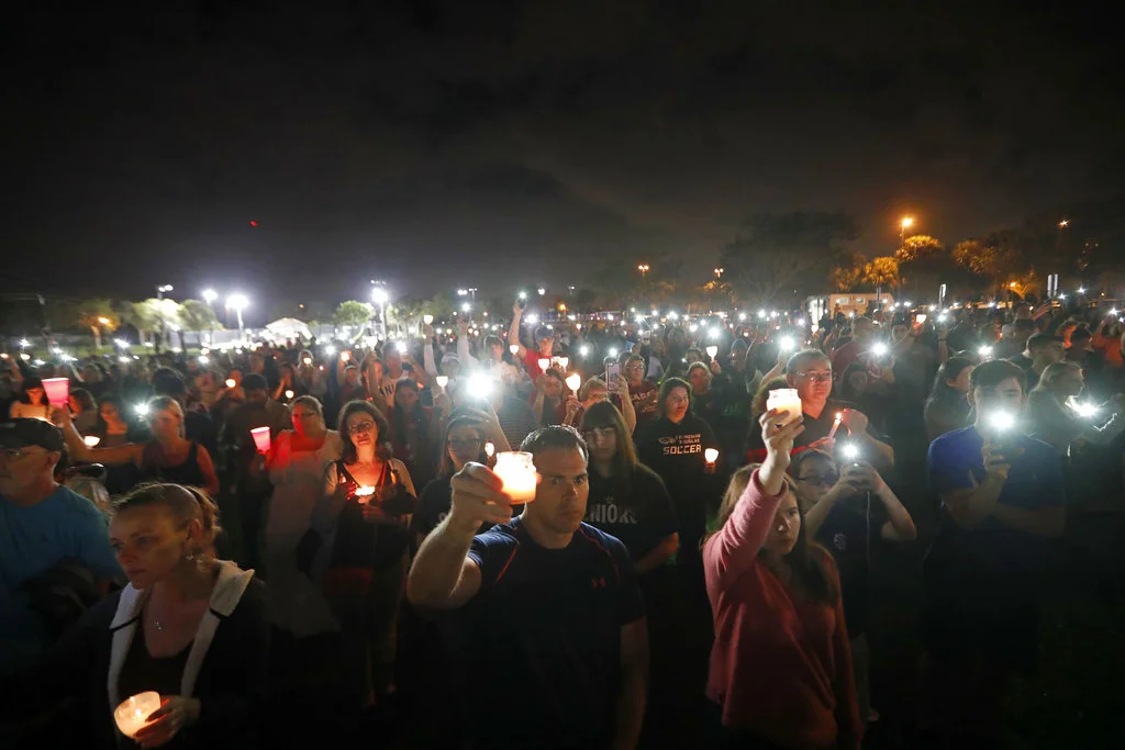 People participate in a candlelight vigil in memory of the 17 students and faculty who were killed in the Wednesday mass shooting at Marjory Stoneman Douglas High School in Parkland, Fla., Monday, Feb. 19, 2018. Nikolas Cruz, a former student, was charged with 17 counts of premeditated murder on Thursday. (Gerald Herbert/AP)