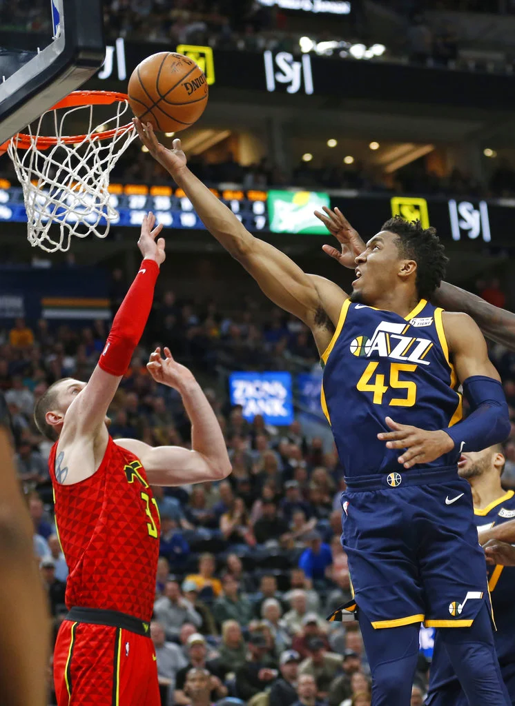 Utah Jazz guard Donovan Mitchell (45) lays the ball up as Atlanta Hawks forward Mike Muscala (31) defends during the second half of an NBA basketball game Tuesday, March 20, 2018, in Salt Lake City. (AP Photo/Rick Bowmer)