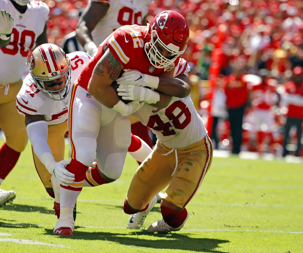 Kansas City Chiefs fullback Anthony Sherman (42) runs against a tackle by San Francisco 49ers linebackers Malcolm Smith (51) and Fred Warner (48) during the first half of an NFL football game in Kansas City, Mo., Sunday, Sept. 23, 2018. (AP Photo/Charlie Riedel)