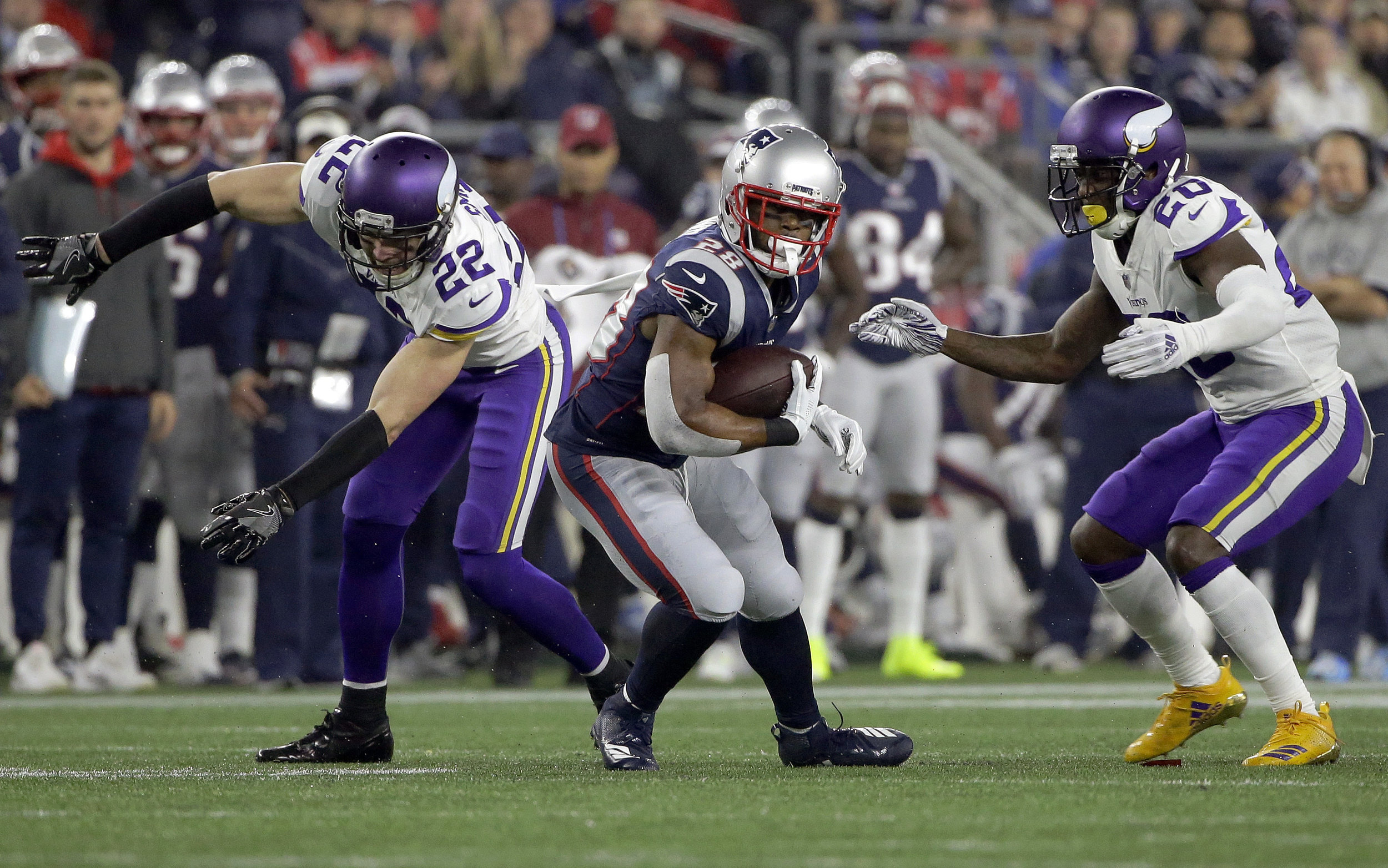 New England Patriots running back James White, center, runs from Minnesota Vikings defenders during a game on Sunday, Dec. 2 in Foxborough. (Steven Senne/AP)