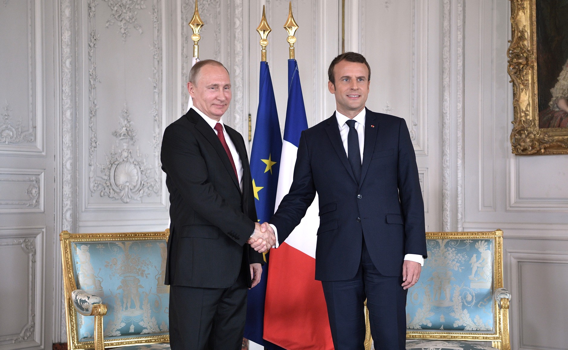 Russian President Vladimir Putin (left) and French President Emmanuel Macron shake hands and pose for a picture in a meeting on May 29, 2017. (Photo courtesy of WikiMedia Commons)