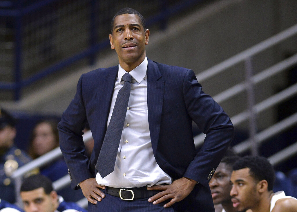 FILE - In this Feb. 7, 2018, file photo, Connecticut head coach Kevin Ollie watches from the sideline during the first half an NCAA college basketball game in Storrs, Conn. The University of Connecticut has announced it is self-imposing penalties, including the loss of a scholarship for the 2019-20 season, for violations of NCAA rules under former basketball coach Kevin Ollie, Friday, Jan. 18, 2019. The school said it also will restrict its recruiting and pay a fine of $5,000.(AP Photo/Jessica Hill, File)