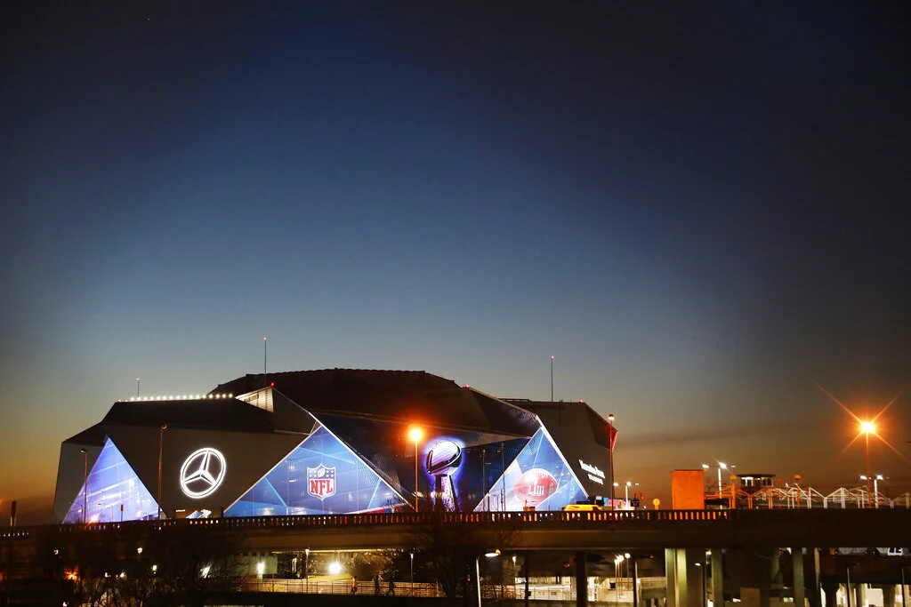 The sun sets behind Mercedes-Benz Stadium ahead of Sunday's NFL Super Bowl 53 football game between the Los Angeles Rams and New England Patriots in Atlanta, Wednesday, Jan. 30, 2019. (AP Photo/David Goldman)