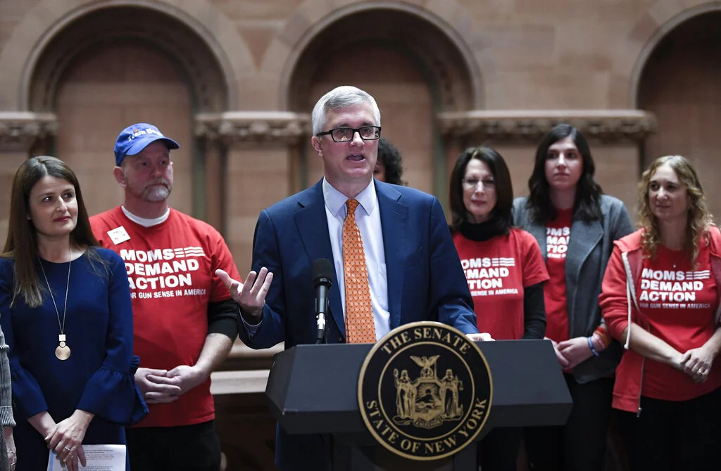 Sen. Brian Kavanagh, D-Manhattan, stands with gun control advocates during a news conference after a Senate session announcing legislation reforms to protect New Yorkers from gun violence in the at the state Capitol on Tuesday, Jan. 29, 2019, in Albany, N.Y. (AP Photo/Hans Pennink)