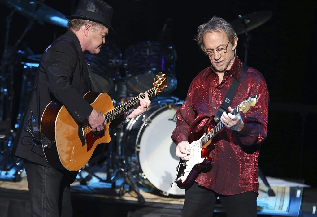 In this June 30, 2016 photo, Micky Dolenz, left, and Peter Tork of The Monkees perform at the Joint at the Hard Rock Hotel and Casino in Tulsa, Okla. Tork, who rocketed to teen idol fame in 1965 playing the lovably clueless bass guitarist in the made-for-television rock band The Monkees, died Thursday, Feb. 21, 2019, of complications related to cancer, according to his son Ivan Iannoli. He was 77. (Tom Gilbert/Tulsa World via AP)