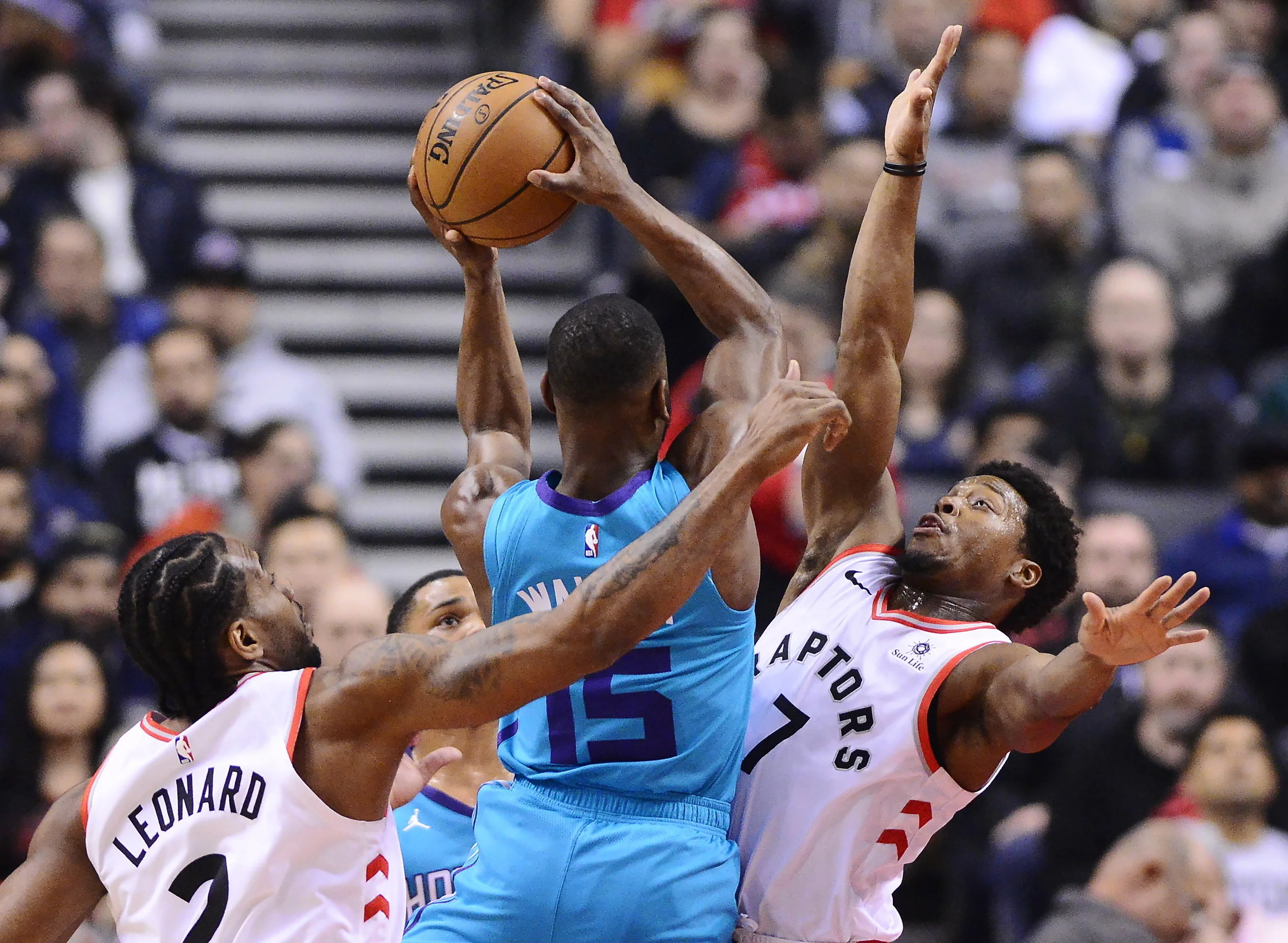 Charlotte Hornets guard Kemba Walker (15) drives between Toronto Raptors forward Kawhi Leonard, left, and guard Kyle Lowry during the first half of an NBA basketball game Sunday, March 24, 2019, in Toronto. (Frank Gunn/The Canadian Press via AP)