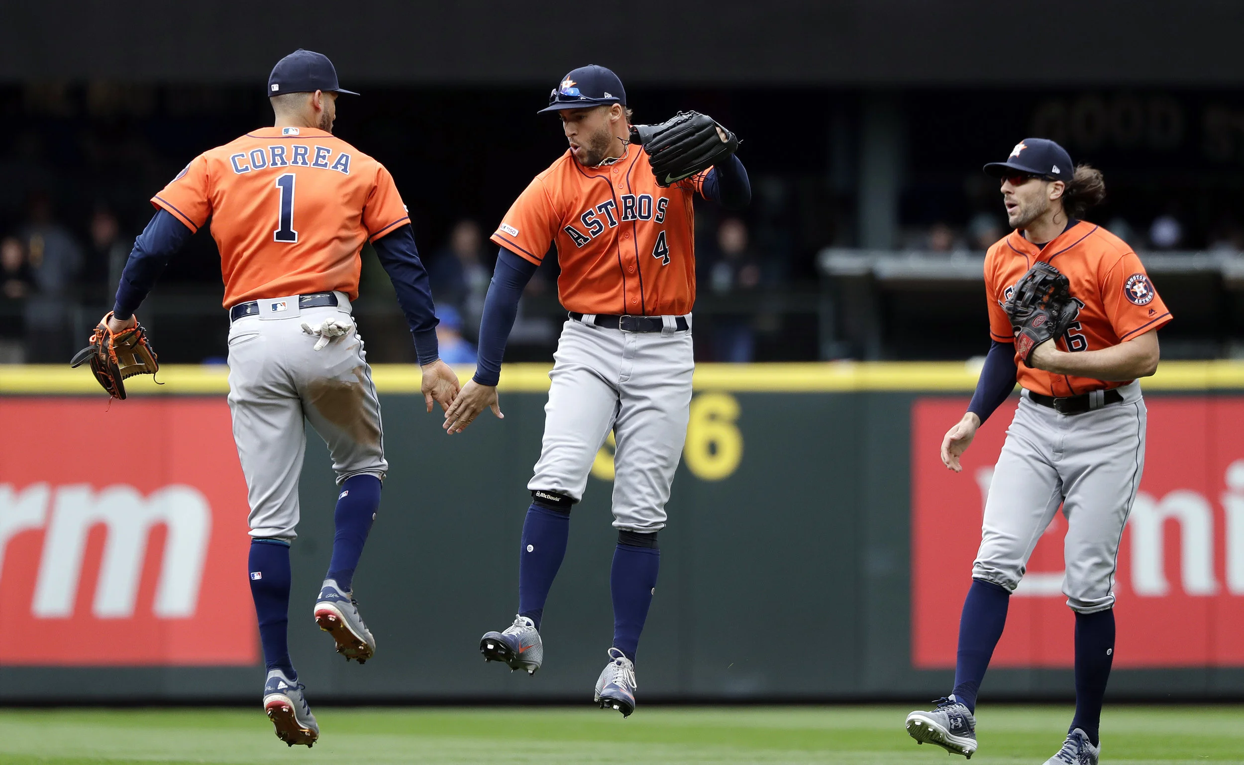 Houston Astros' Carlos Correa (1), George Springer (4), and Jake Marisnick celebrate after the team beat the Seattle Mariners in a baseball game Sunday, April 14, 2019, in Seattle. The Astros won 3-2. (AP Photo/Elaine Thompson)