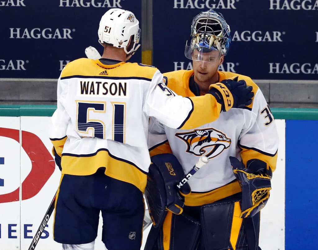 Nashville Predators' Austin Watson (51) taps goaltender Pekka Rinne, right, on the shoulder as they stand by the bench following their 2-1 overtime loss to the Dallas Stars in Game 6 of an NHL hockey first-round playoff series in Dallas, Monday, April 22, 2019. (AP Photo/Tony Gutierrez)
