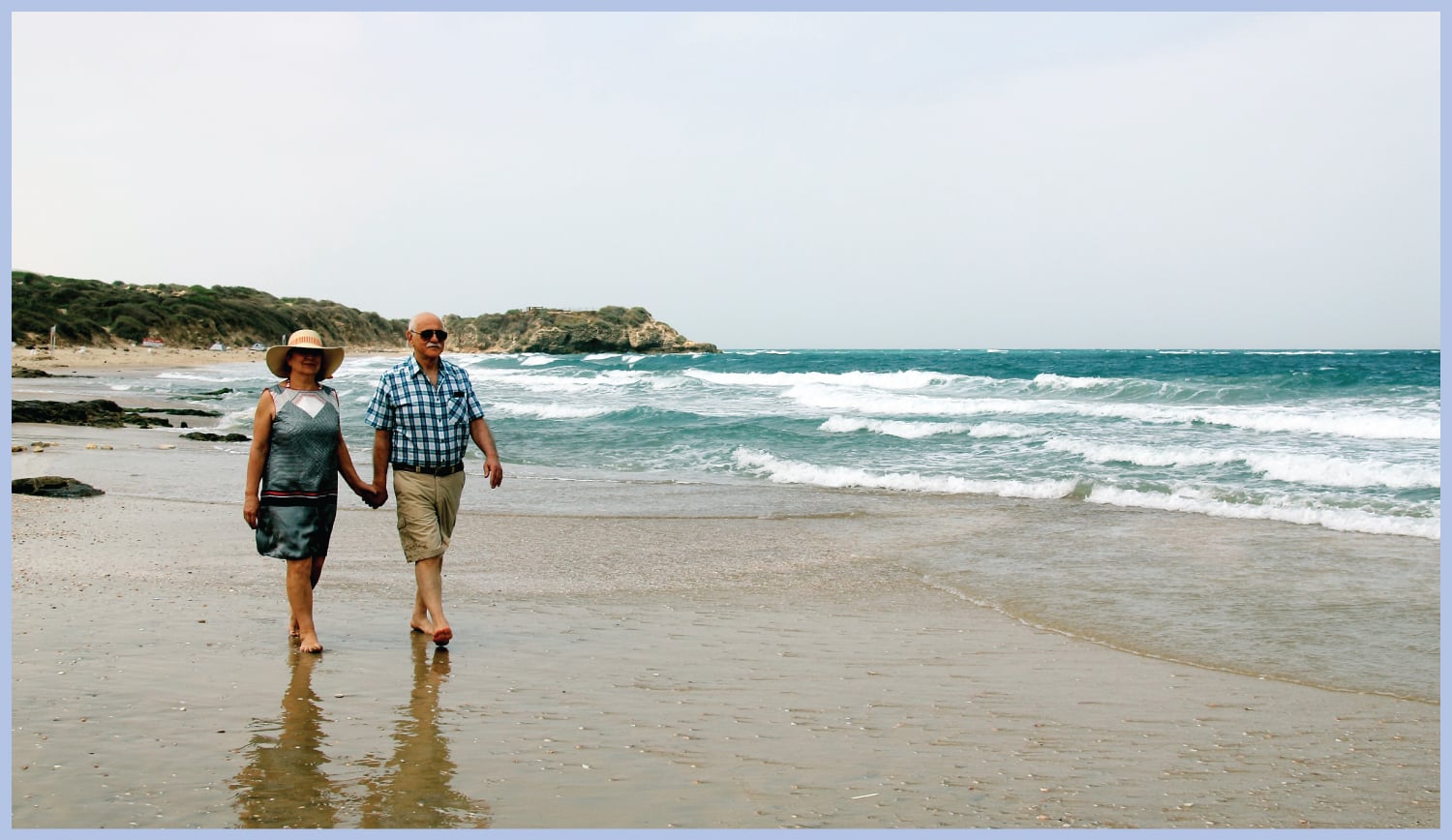 Man and woman walking on beach.