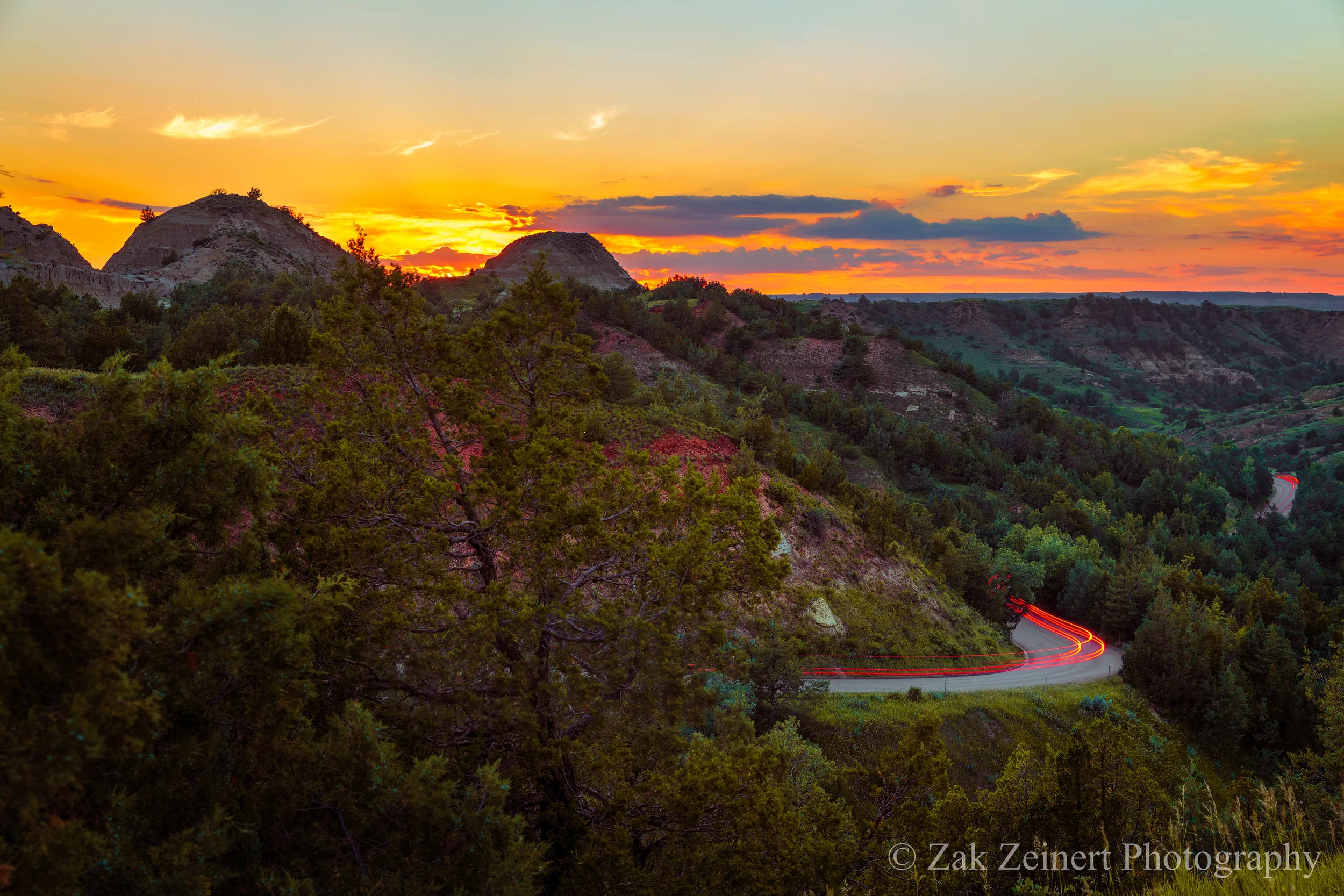 The sun sets behind Scoria Point overlook on the 36-mile park loop