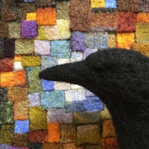 The needle felted crow is in front of one of my felted mosaic art works... it's a work in progress