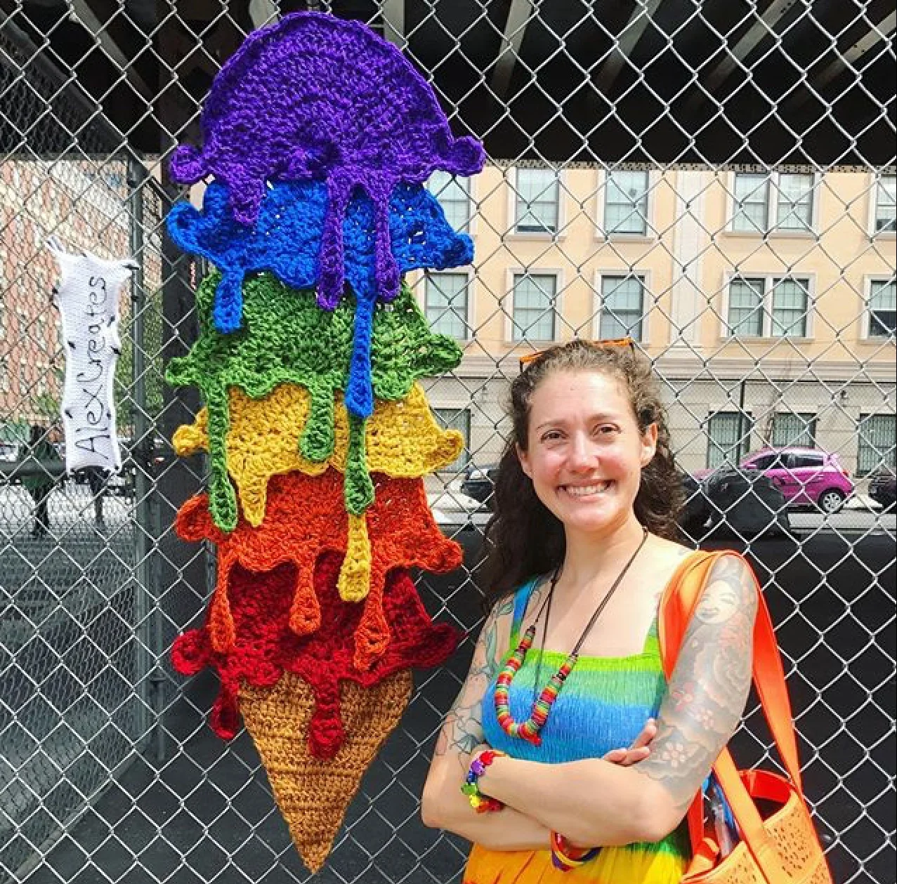 Jessie standing by a yarn bomb piece made by Alex Reynoso from Alexcreates.