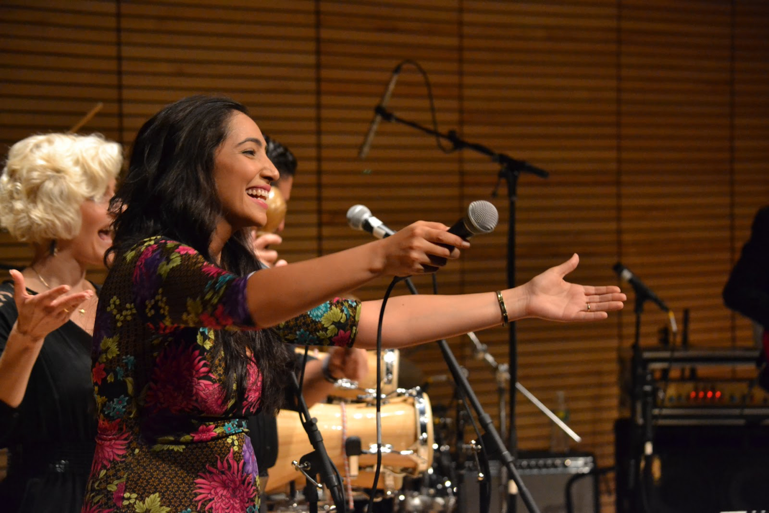 Leslie Cartaya lending the microphone to the audience during the Day of Orula Celebration.