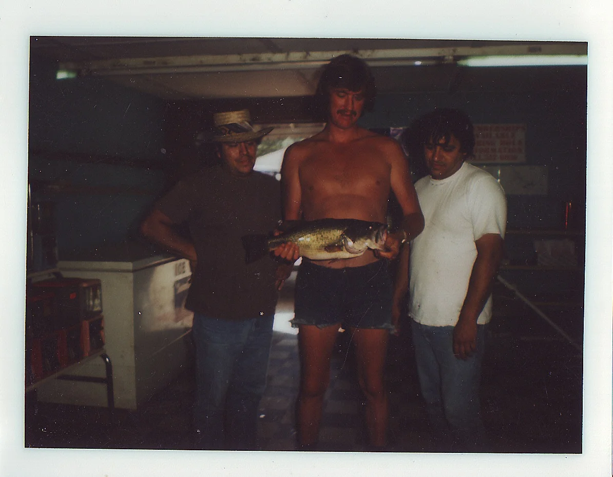 Dad towering over his buddies with a little fish