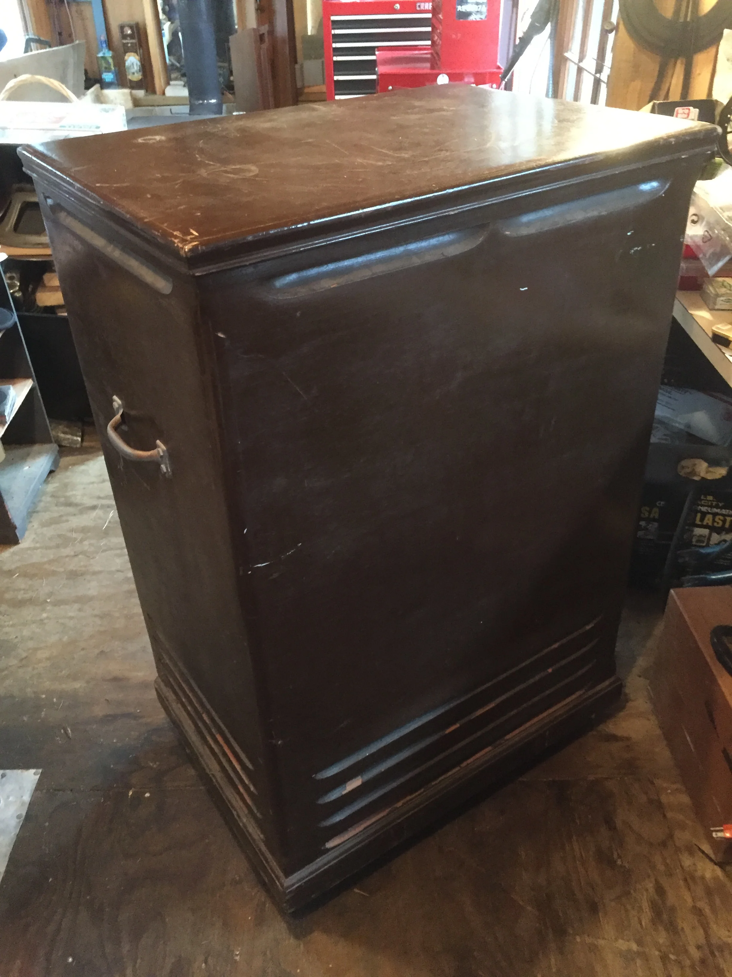 Cabinet needs repair. P ainted brown, with handles and wobbly casters