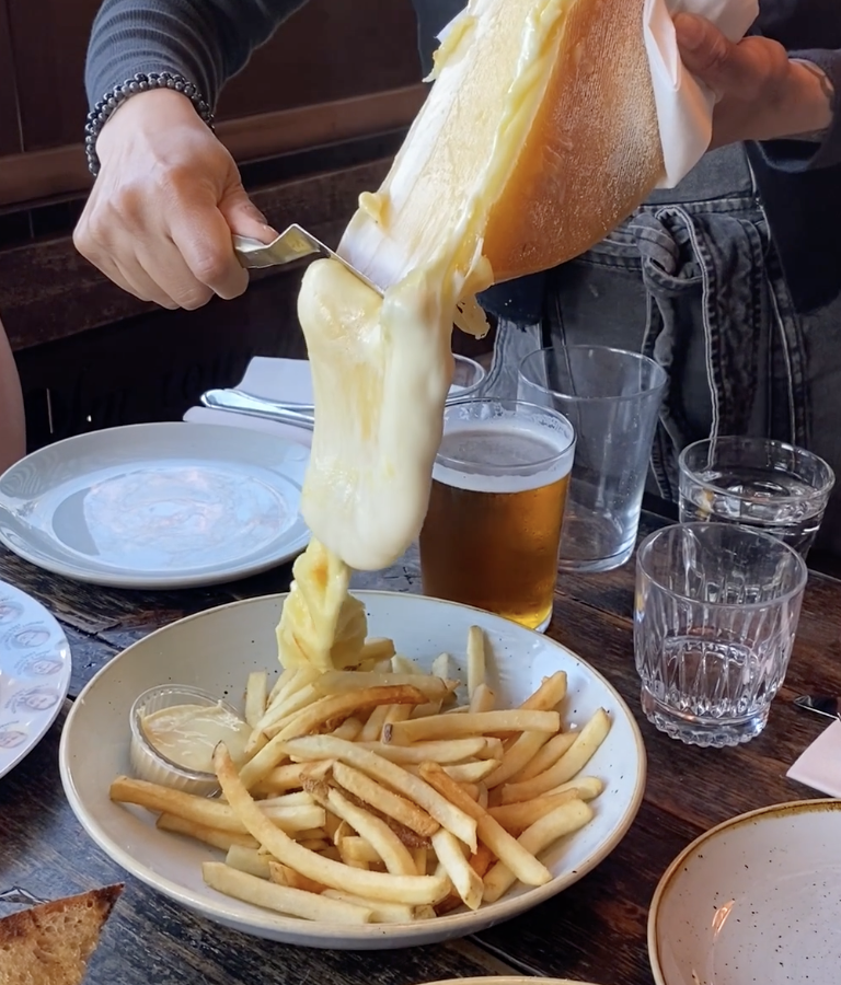 Melted cheese over fries at Craft and Commerce in San Diego