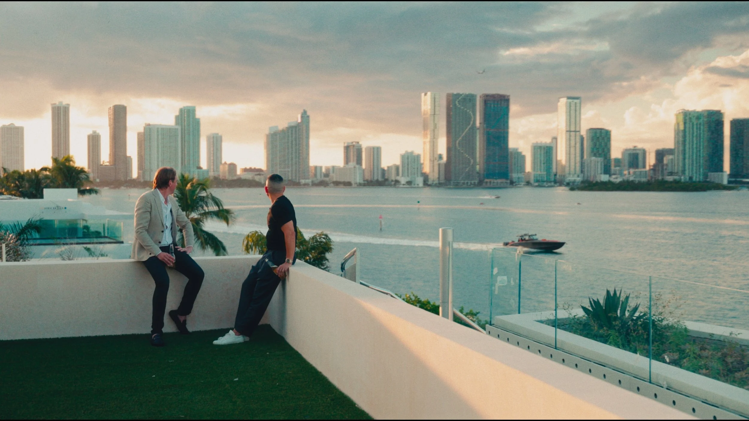 Architectural photograph of two people overlooking Biscayne Bay and the Miami skyline from a Venetian Islands waterfront terrace. Captured by Miami and Los Angeles-based architectural photographer Christian Santiago.