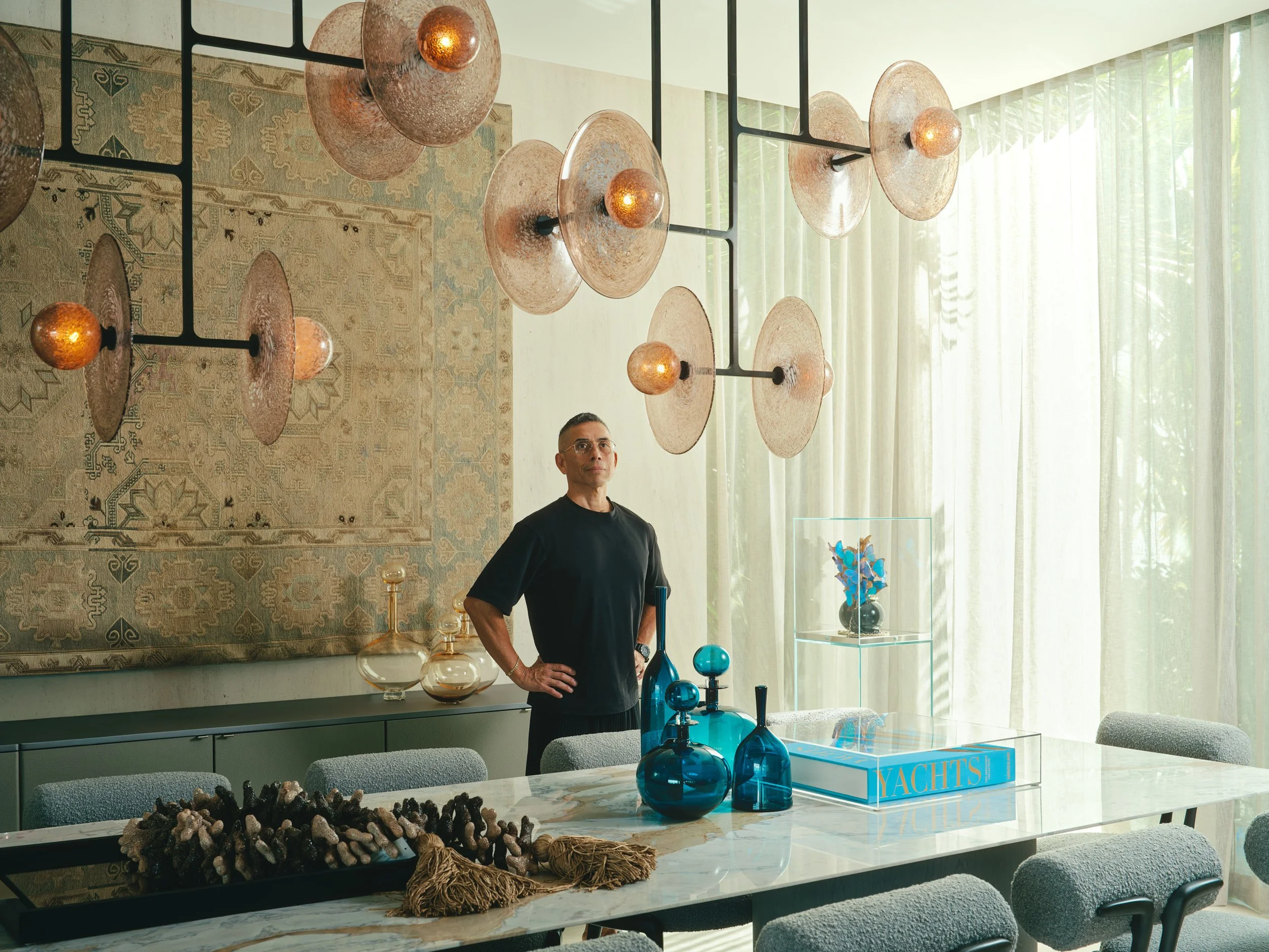 Architectural photograph of a designer standing in a luxury dining room inside a Venetian Islands waterfront residence in Miami. Captured by Miami and Los Angeles-based architectural photographer Christian Santiago.
