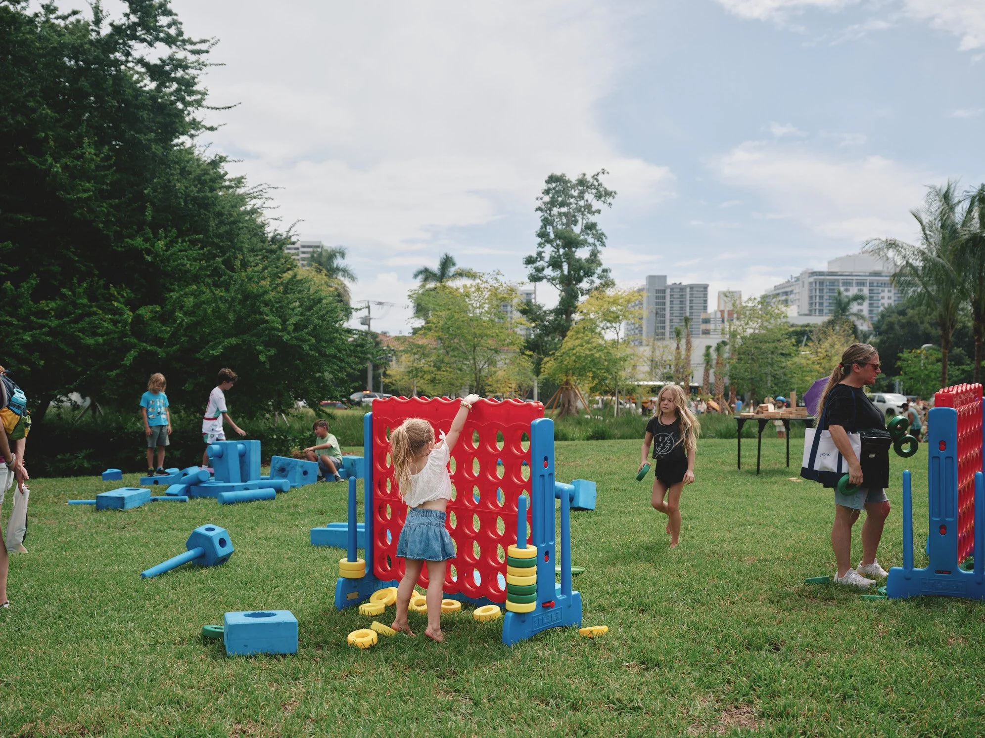 Landscape architectural photograph of children playing lawn games on an open grass field in Bayshore Park in Miami Beach, illustrating the park’s flexible recreational spaces and family-friendly public environment. Captured by Miami and Los Angeles-b