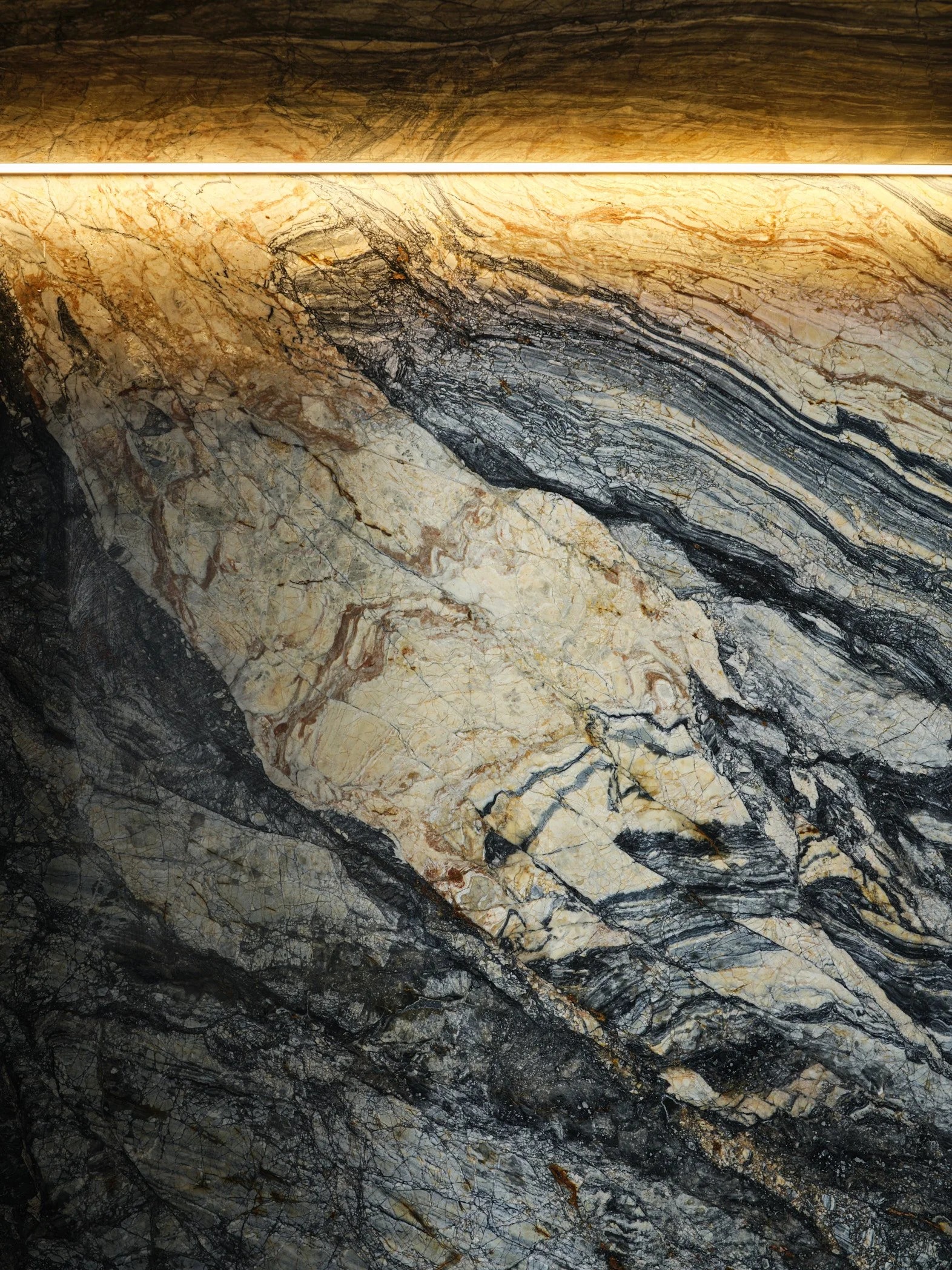 Architectural photograph of a dramatic backlit marble feature wall inside a luxury waterfront residence on the Venetian Islands in Miami, highlighting the natural veining and sculptural stone textures. Captured by Miami and Los Angeles-based architec