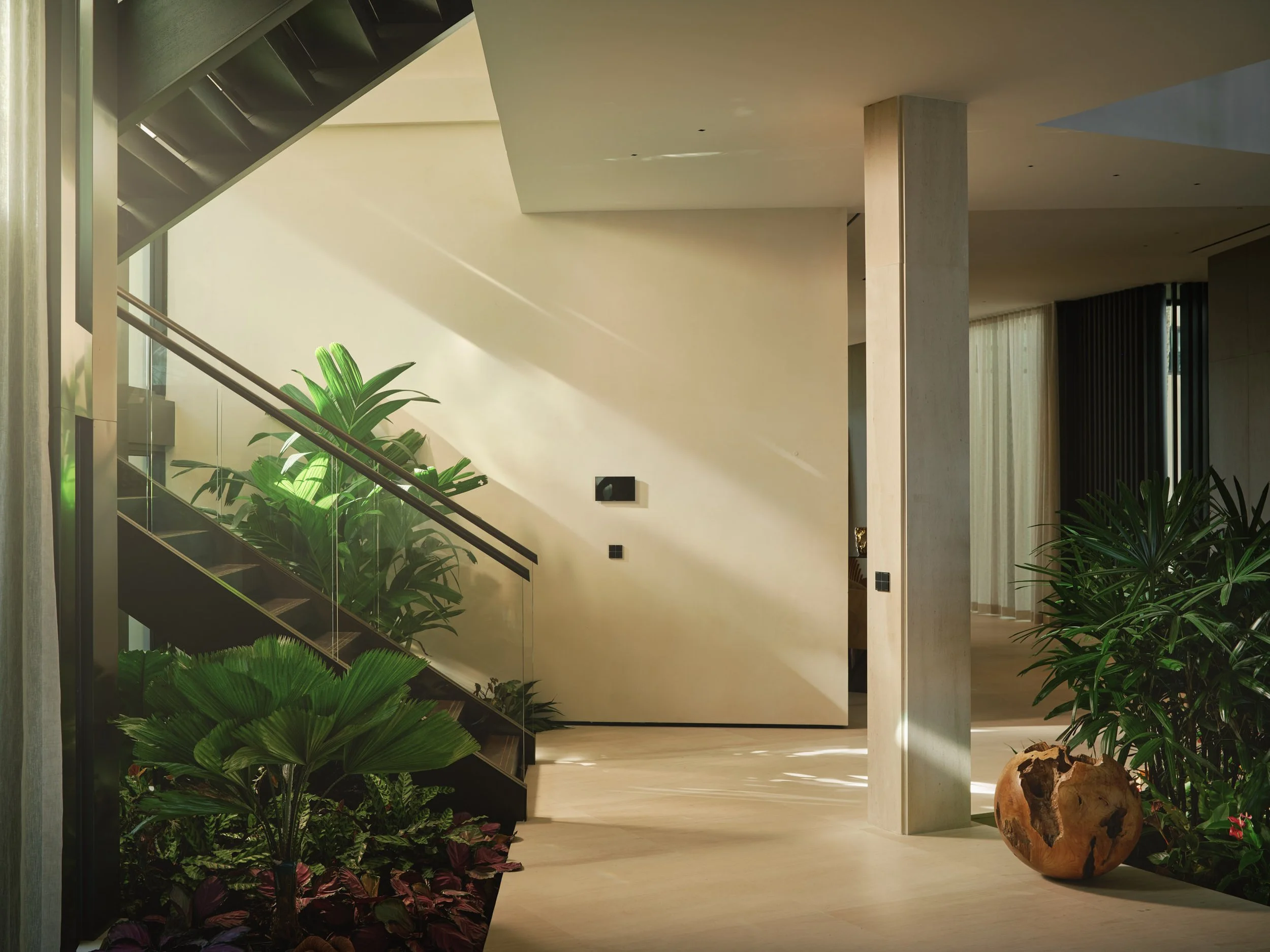 Architectural photograph of a minimalist staircase and interior tropical garden inside a Venetian Islands waterfront residence in Miami. Captured by Miami and Los Angeles-based architectural photographer Christian Santiago