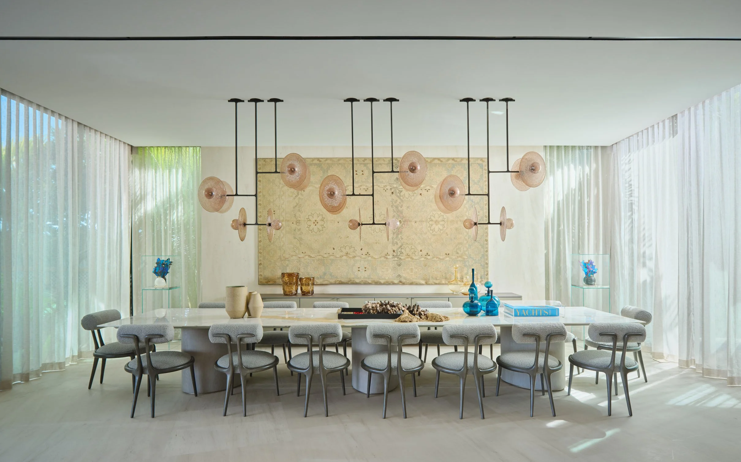 Architectural photograph of a modern luxury dining room with sculptural chandelier and floor-to-ceiling curtains inside a Venetian Islands residence in Miami. Captured by Miami and Los Angeles-based architectural and travel photographer Christian San