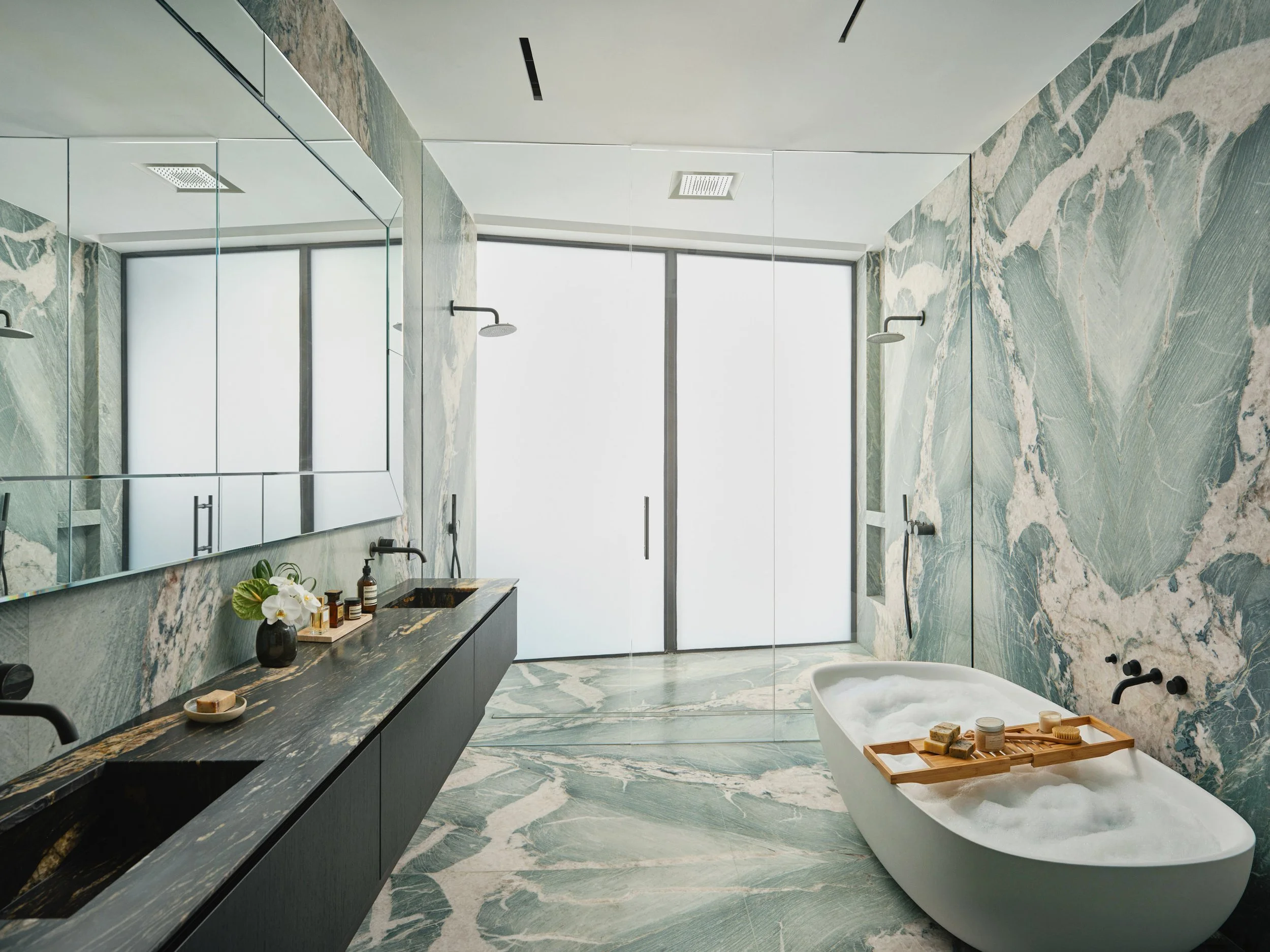 Architectural photograph of a luxury marble bathroom with freestanding tub inside a Venetian Islands waterfront residence in Miami. Captured by Miami and Los Angeles-based architectural photographer Christian Santiago.