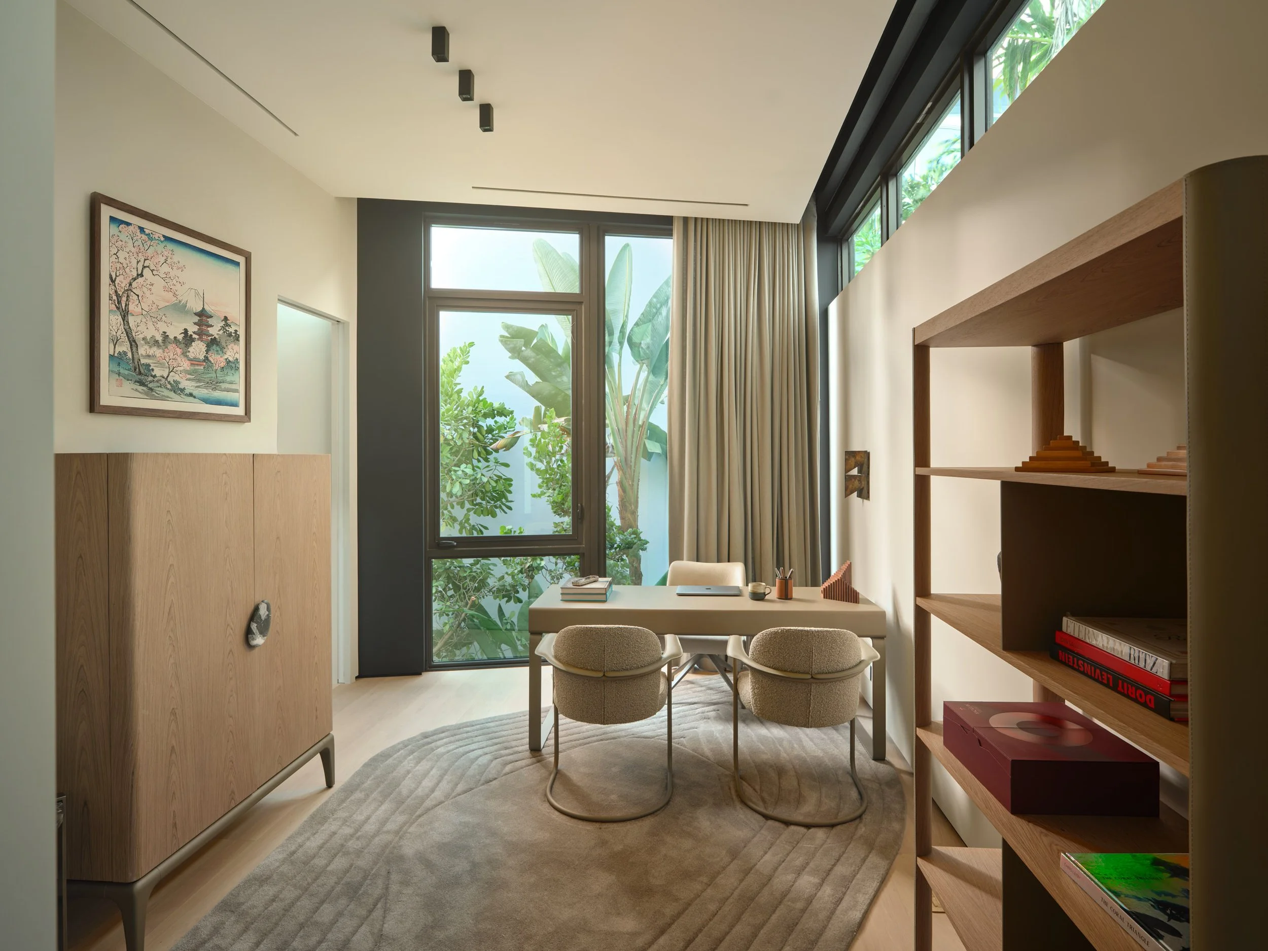 Architectural photograph of a minimalist home office with floor-to-ceiling windows and tropical garden views inside a modern Venetian Islands residence in Miami. Captured by Miami and Los Angeles-based architectural and travel photographer Christian 