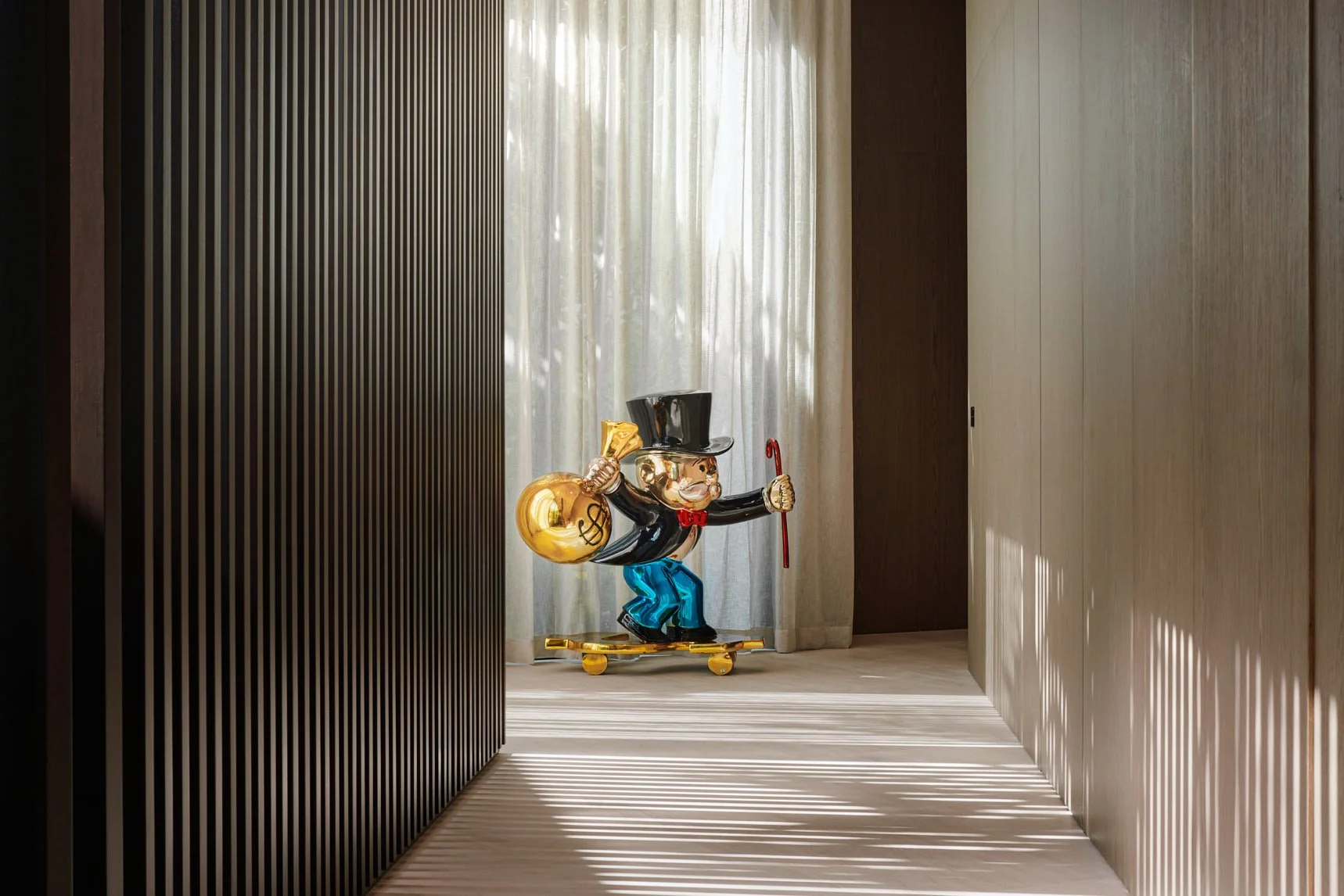 Architectural photograph of an Alec Monopoly sculpture placed within a minimalist hallway of a Venetian Islands luxury residence in Miami. Captured by Miami and Los Angeles-based architectural photographer Christian Santiago