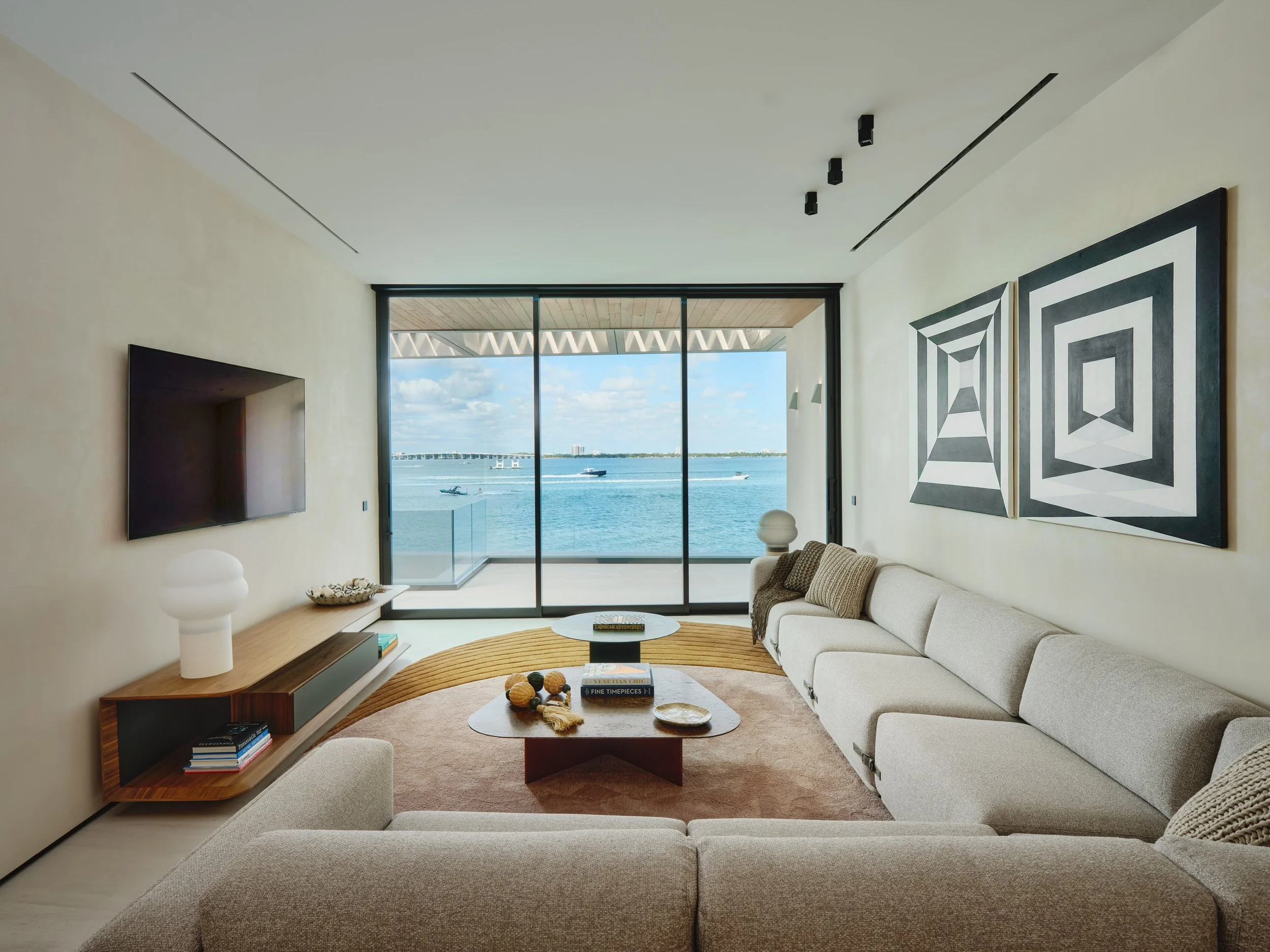Architectural photograph of a modern waterfront living room with panoramic Biscayne Bay views inside a Venetian Islands residence in Miami. Captured by Miami and Los Angeles-based architectural and travel photographer Christian Santiago