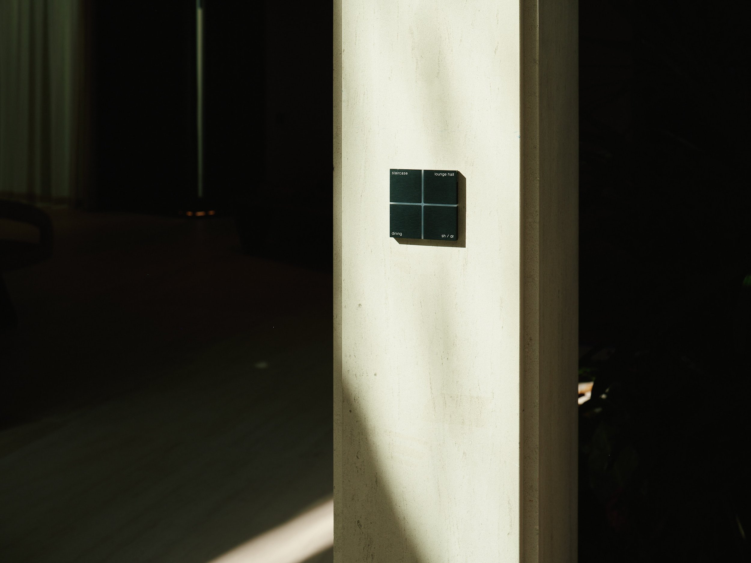 Architectural photograph of a minimalist luxury bathroom featuring a circular mirror, integrated sink, and textured stone wall detail inside a Venetian Islands waterfront residence in Miami. Captured by Miami and Los Angeles-based architectural and t
