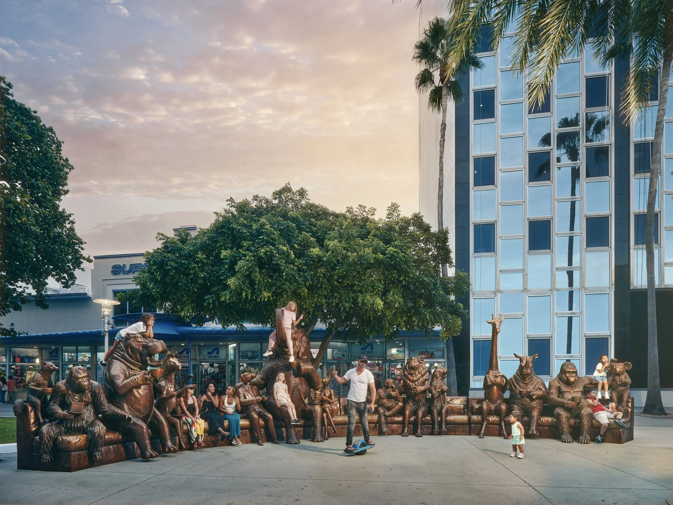 Architectural photograph of Gillie and Marc’s public art installation featuring bronze animal sculptures arranged as a communal seating environment in an urban plaza in Miami. Visitors interact with the sculptures, climbing and gathering among the fi