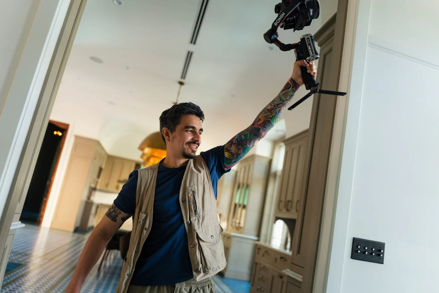 Miami architectural photographer and filmmaker Christian Santiago on location, capturing cinematic footage of a luxury residential interior using a DJI Ronin gimbal.