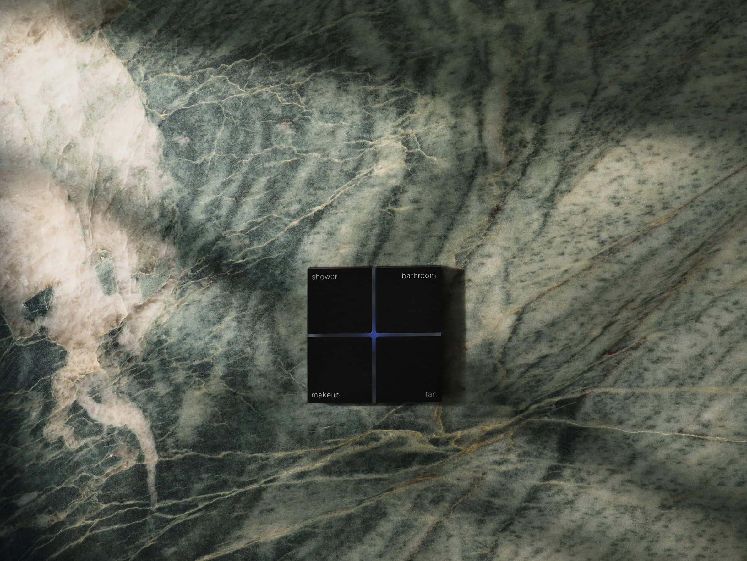 Architectural photograph of a minimalist bathroom control panel set within expressive marble stone in a Venetian Islands waterfront residence in Miami. Captured by Miami and Los Angeles-based architectural photographer Christian Santiago.