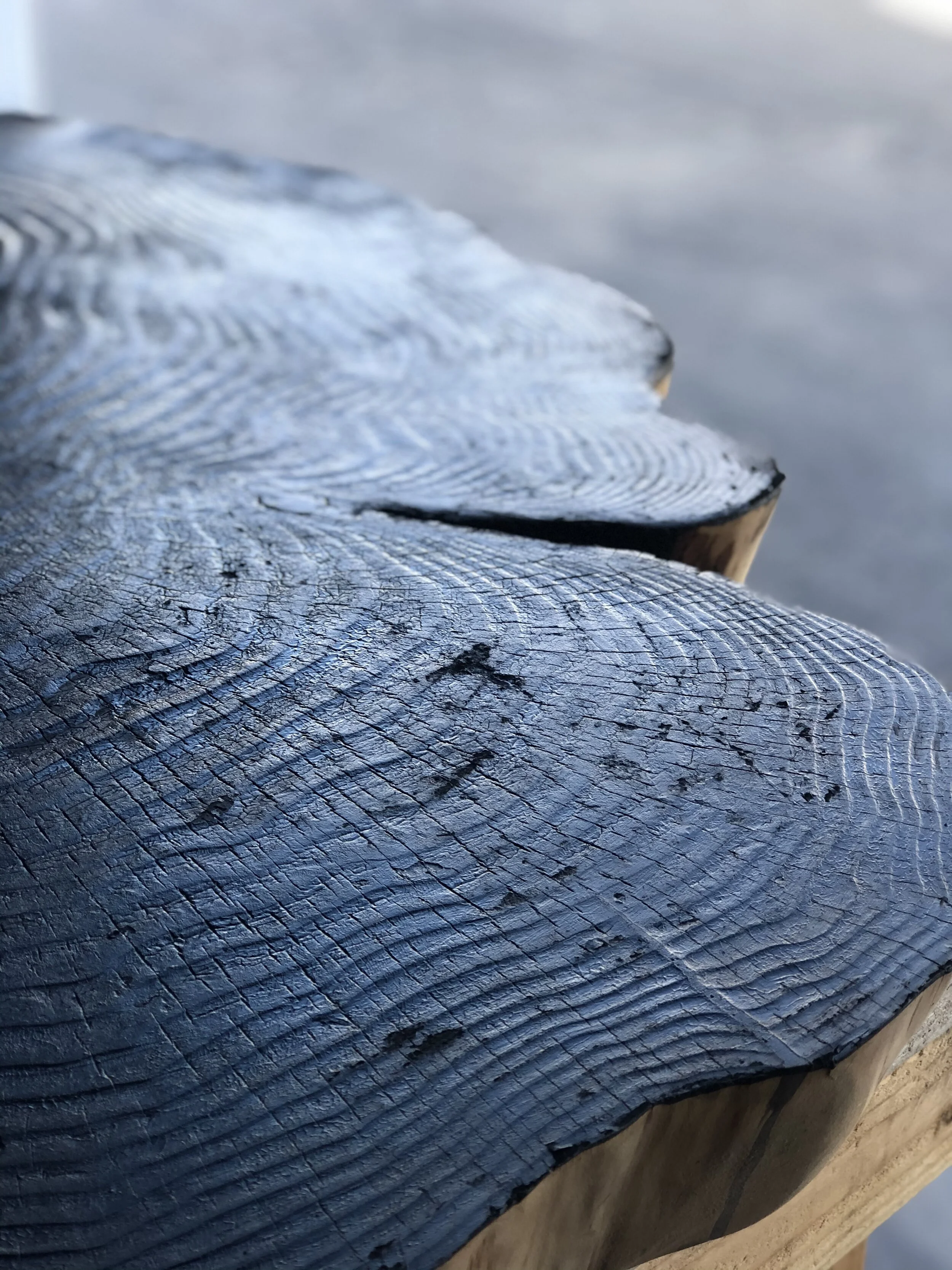 Close-up of a weathered wooden surface with visible crack lines and texture.