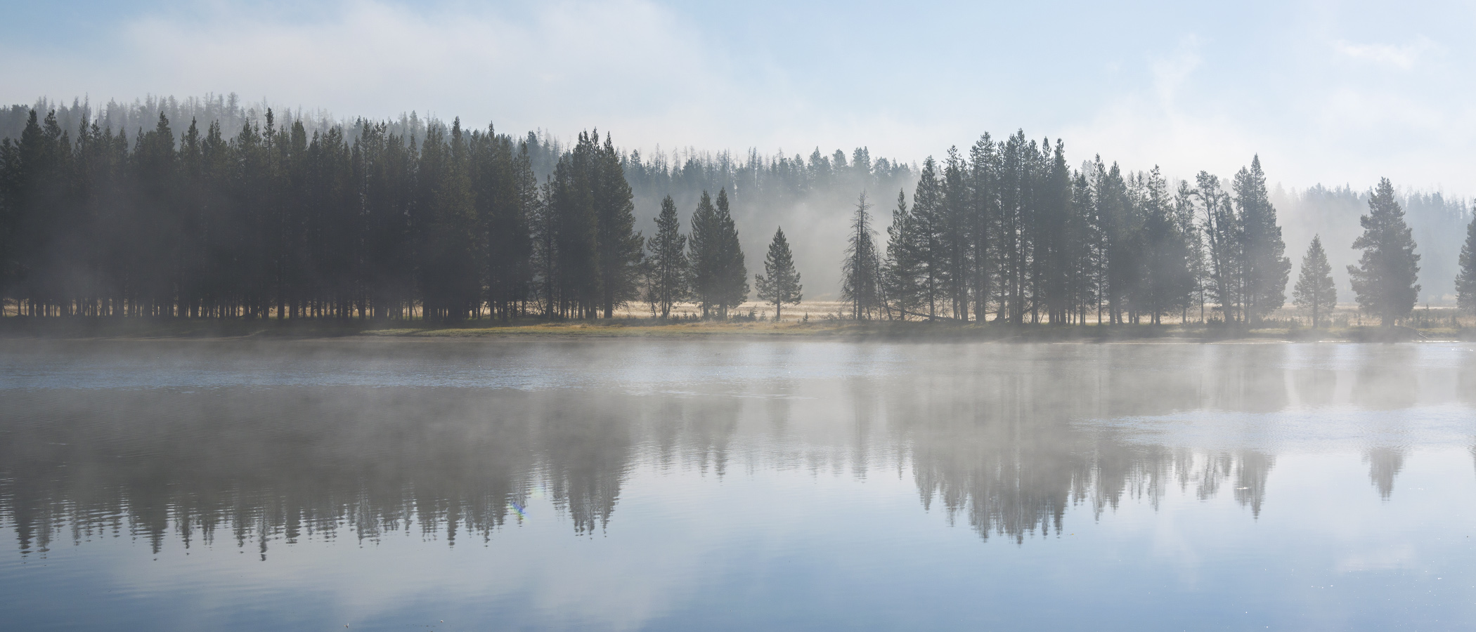 The fog lifts over a river in Yellowstone.