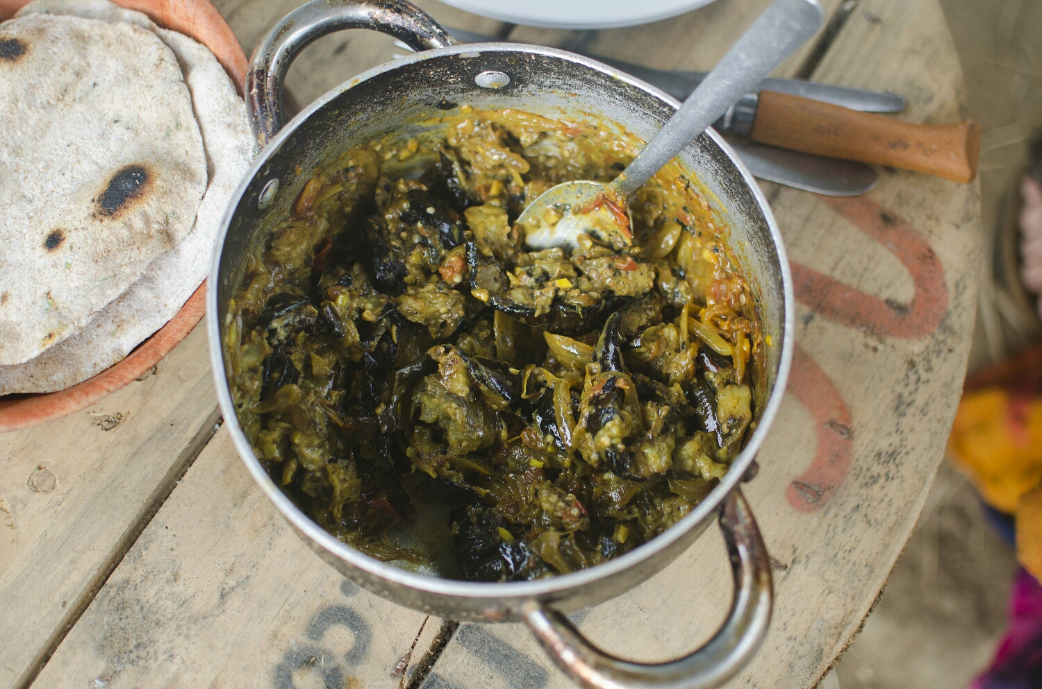 Mash the cooked aubergines into the spices and onions.
