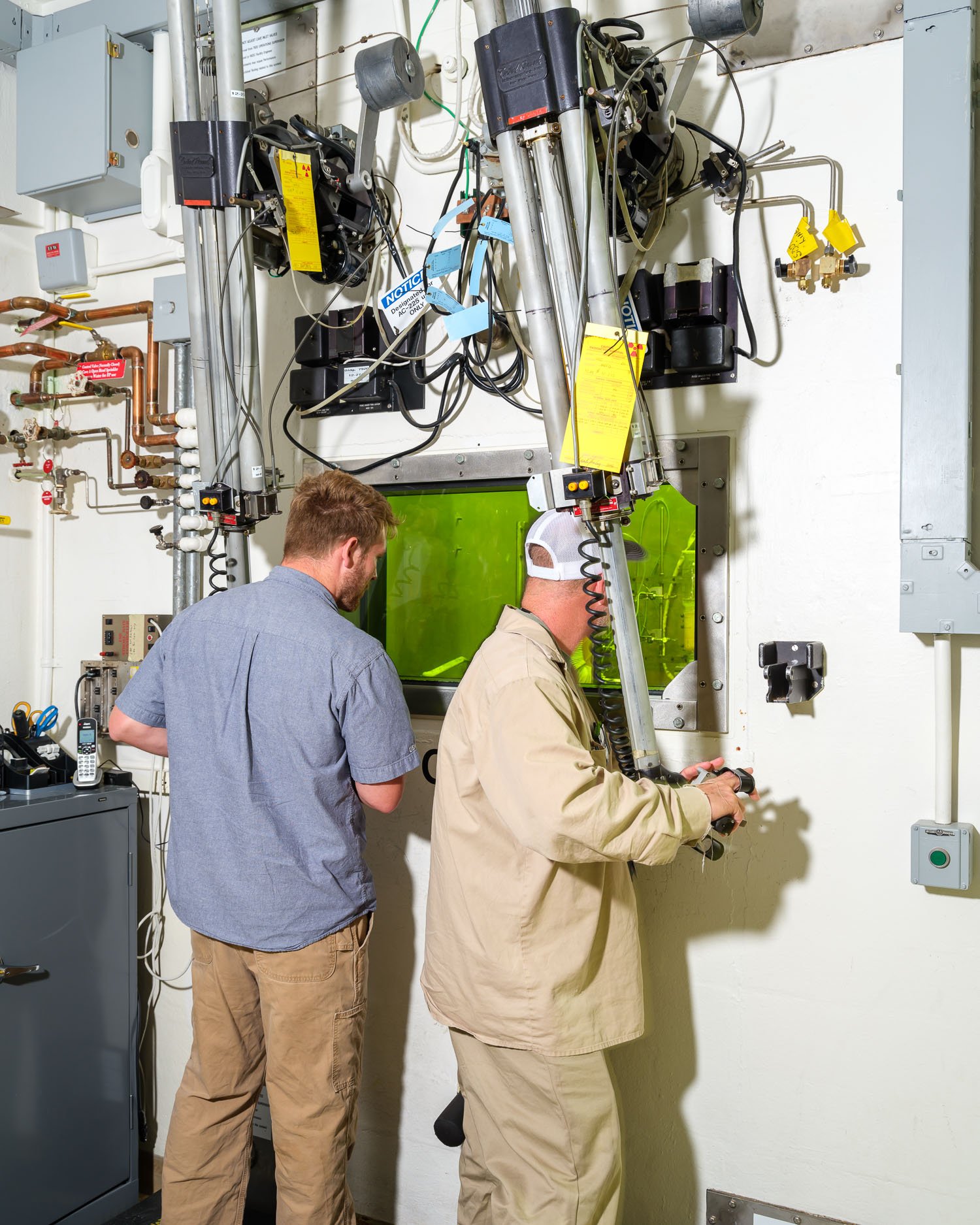  Hot cell at the the Radiochemical Engineering Development Center (REDC) at Oak Ridge National Laboratory. The REDC helps to produce isotopes, nuclear fuels, and other materials. Here, two technicians work with actinium-225 using remote manipulators 