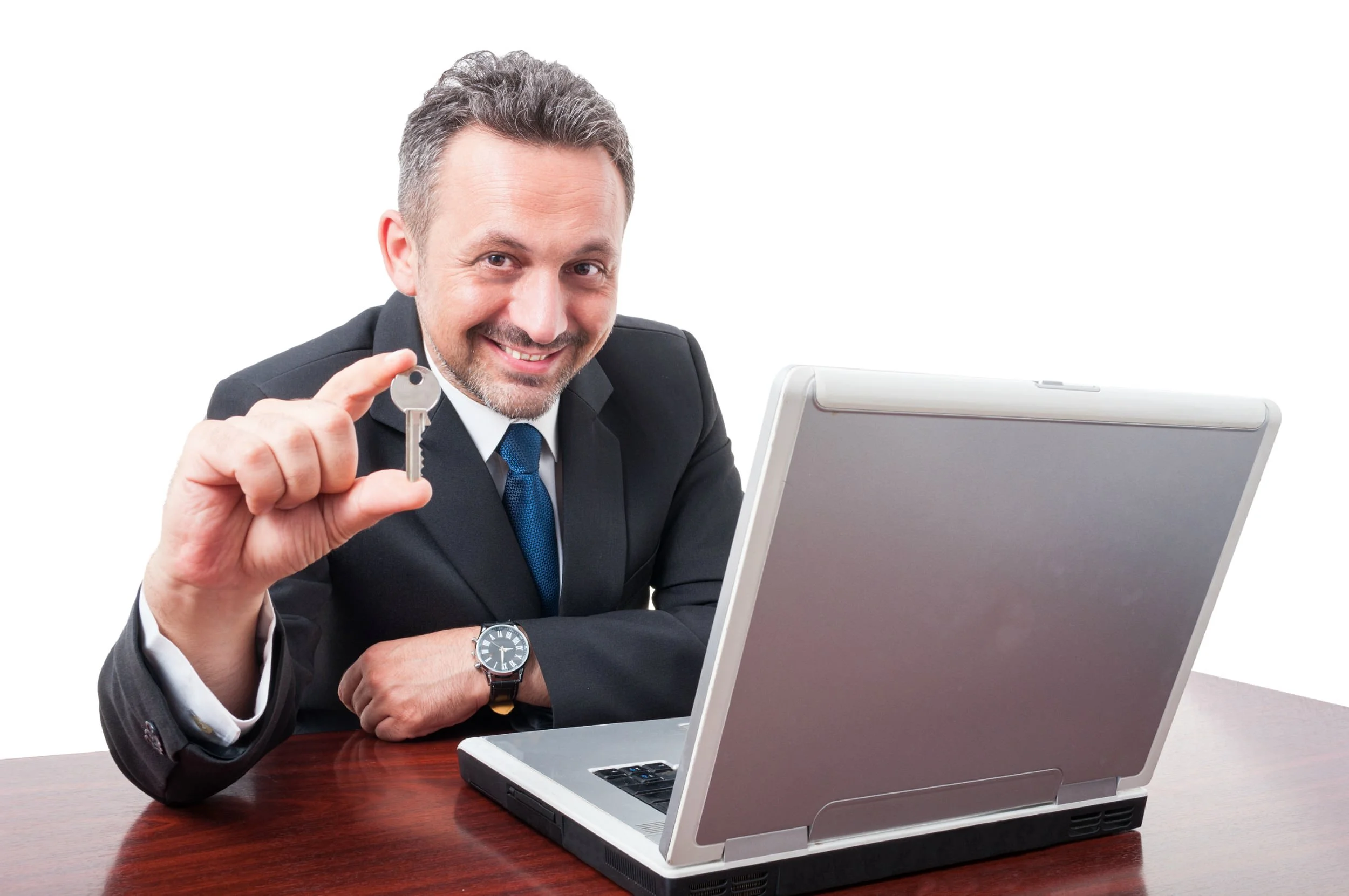 Man holding key while sitting at desk with a laptop