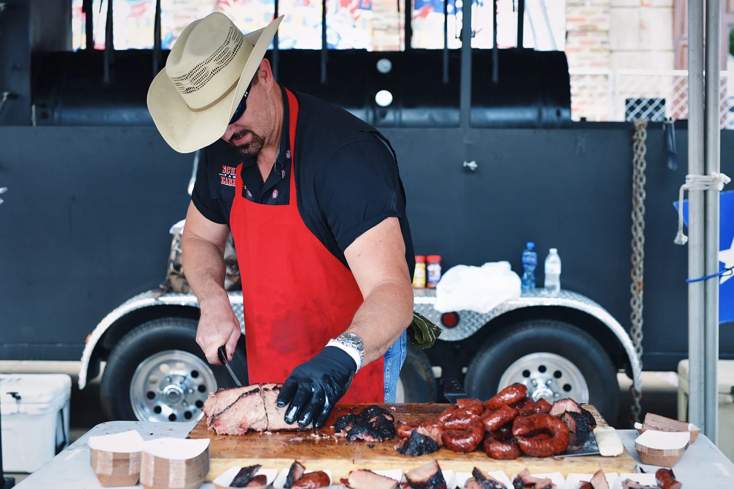 SCHMIDT FAMILY BARBECUE Home: 12532 FM 2244, Bee Cave. Texas Owner & Pitmaster: Chad and Susie-Schmidt Franks, Keith Schmidt Schmidt Family Barbecue brings 75 years of legendary Lockhart tradition to chopping block. The Schmidt family’s impact on barbecue in Texas is well-documented. Anyone who knows anything about Texas ‘cue has heard of Kreuz Market and Smitty’s. From the same family that built these two cathedrals of smoked meat comes Schmidt Family Barbecue. Schmidt Family boasts a wide menu full of incredible smoked meats, from the regular players (brisket, spare ribs, pulled pork), to various weekly specials like beef ribs and prime rib. And of course they'll be slicing that famous Kreuz Sausage at Pints in the Park. Read More: https://tmbbq.com/schmidt-family-barbecue-2014/